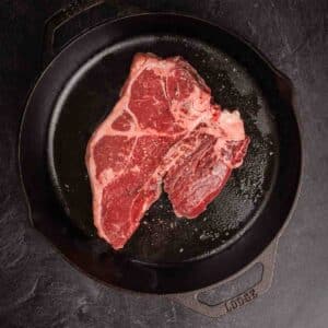 Porterhouse steak in a cast iron pan.