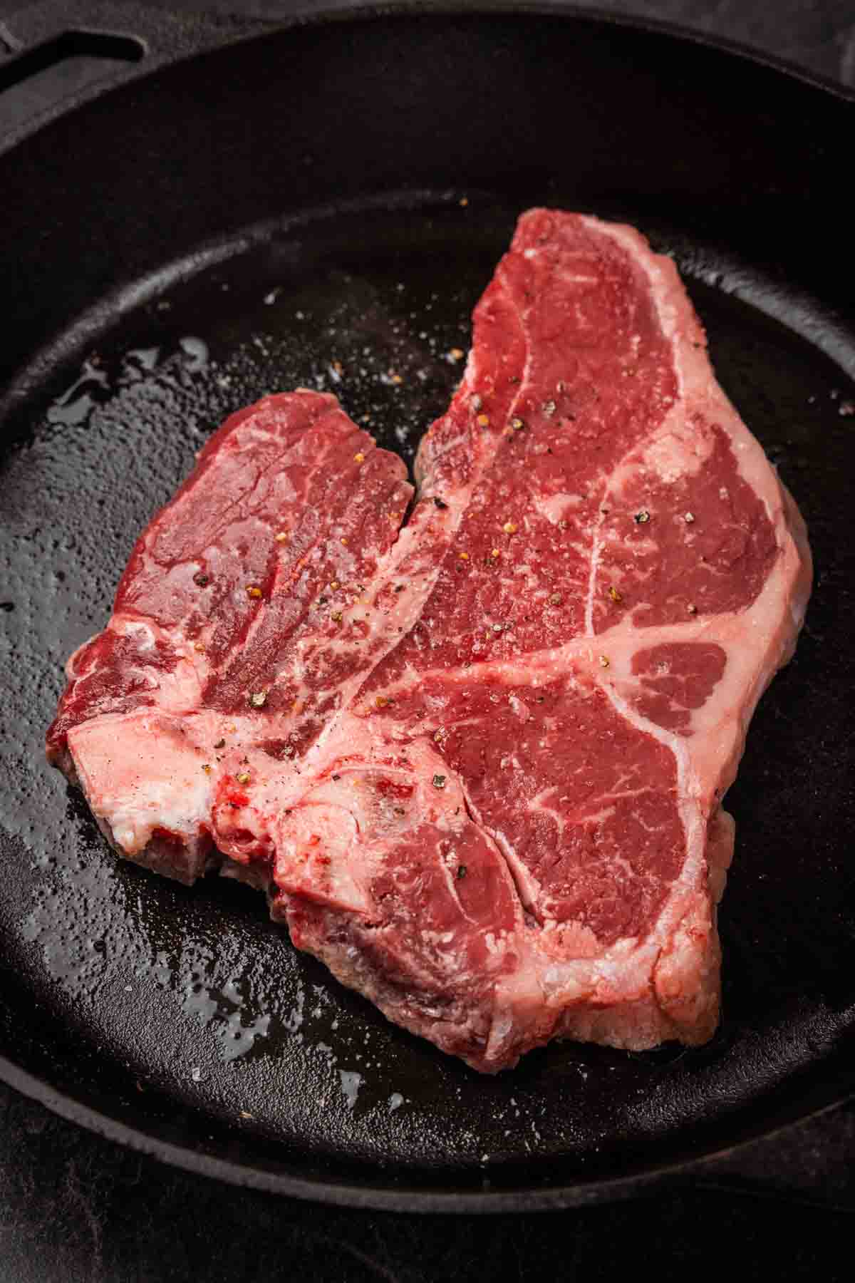 Close up of raw porterhouse in a skillet. 