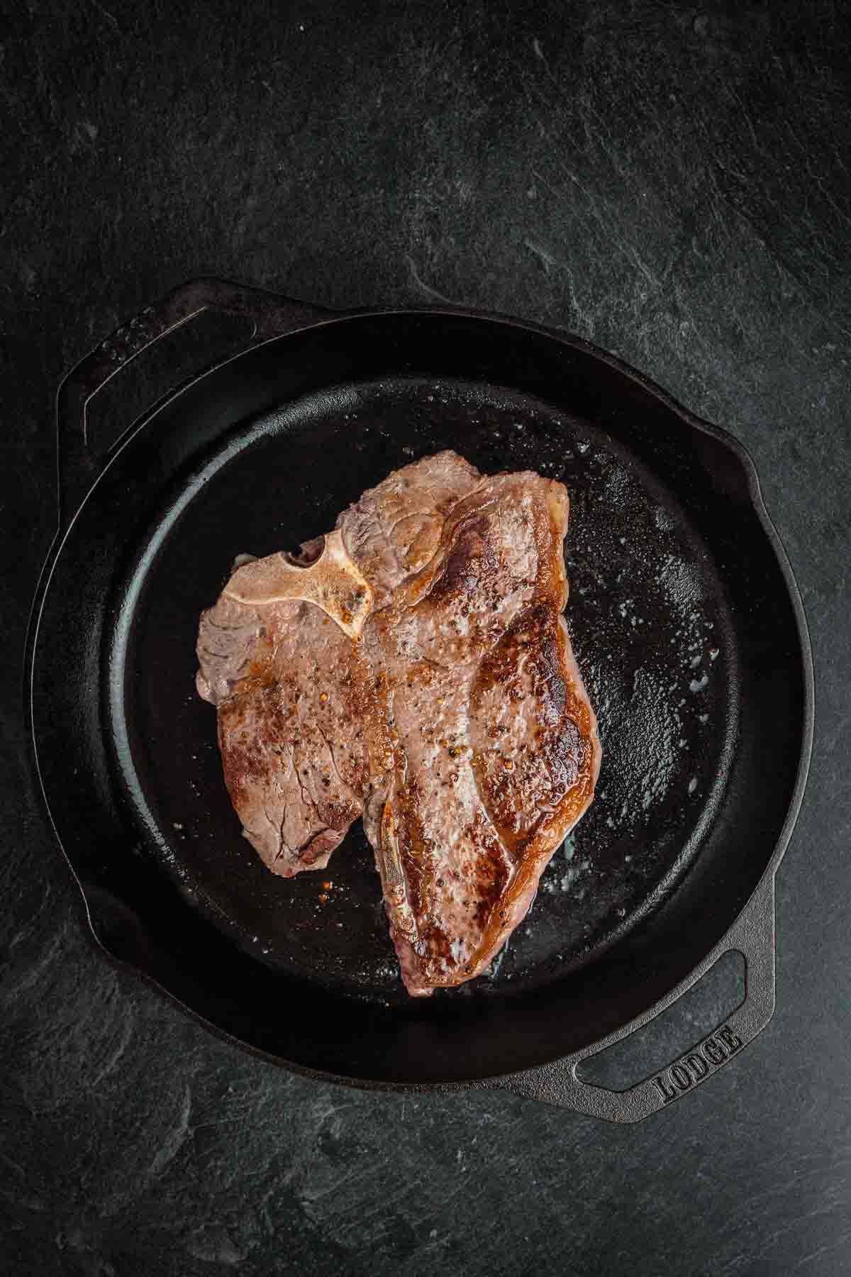 Porterhouse steak, flipped in cast iron to show sear.