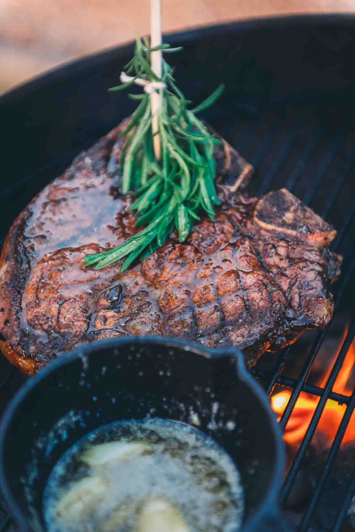 Herb basting a porterhouse steak over direct heat. 