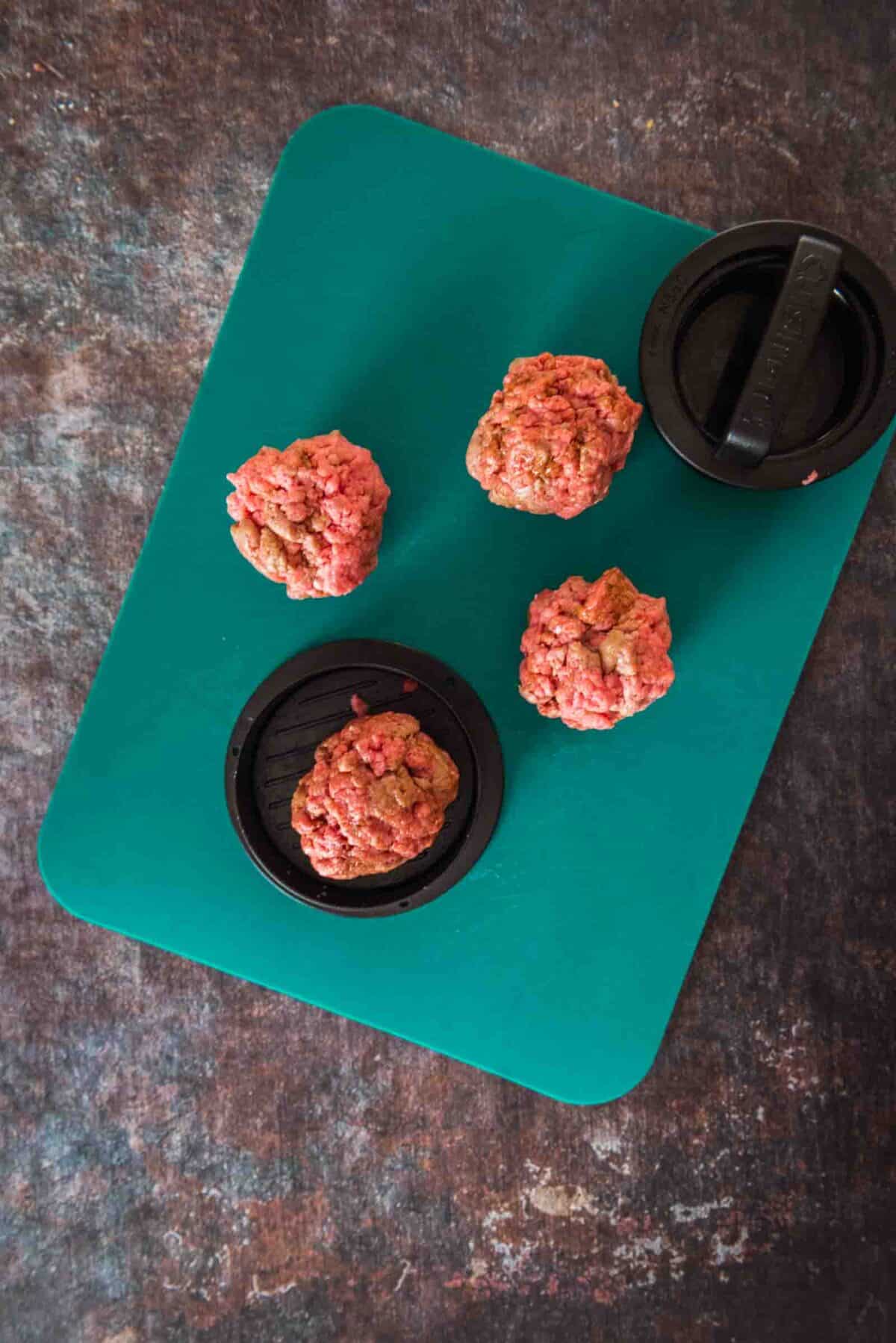 Showing ground beef being divideed into balls to form patties. 