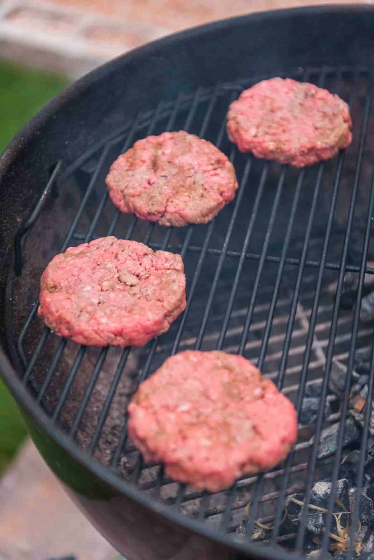 Raw patties on the grill grates. 