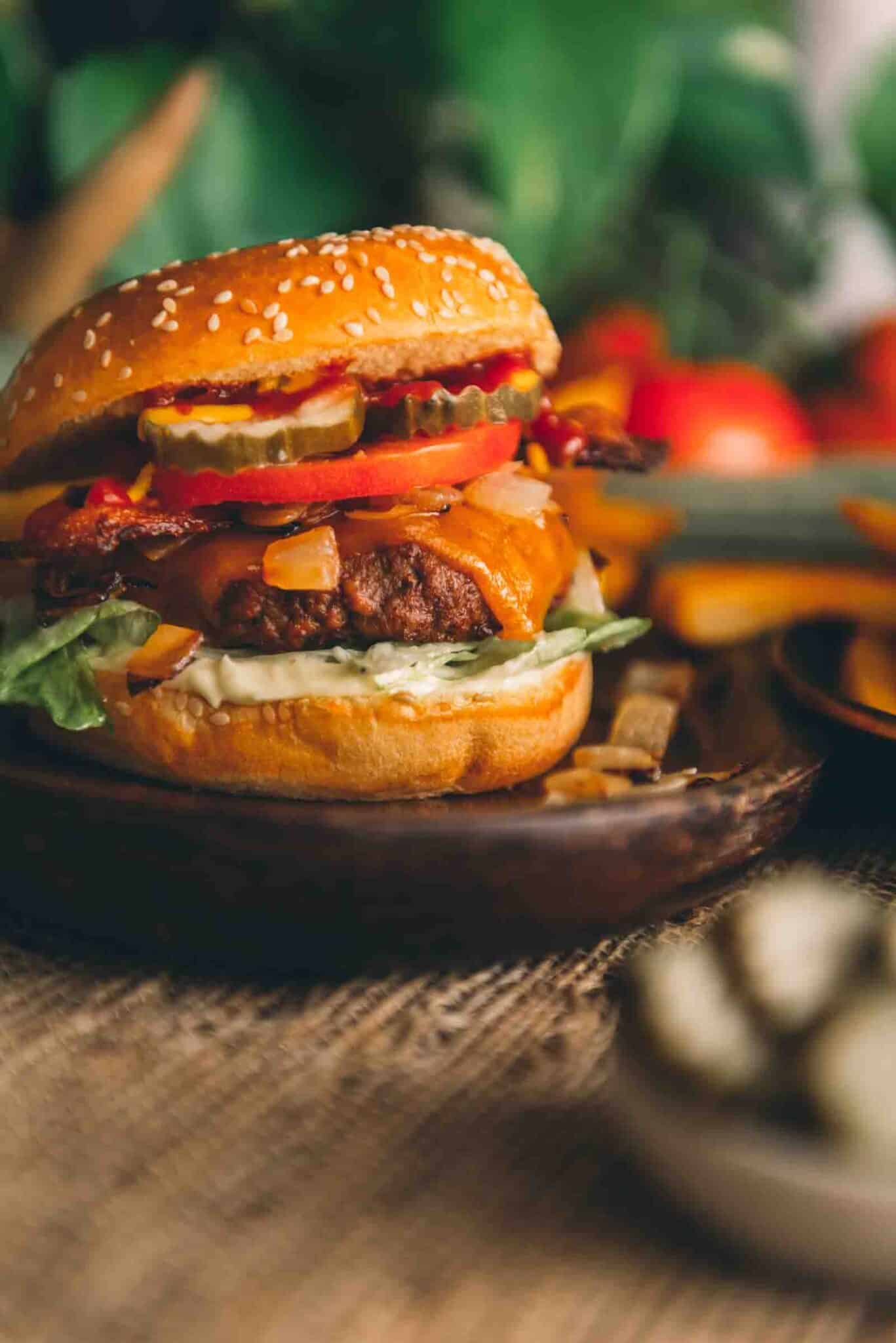 Smoked hamburger on a bun with burger toppings ready to be devoured.