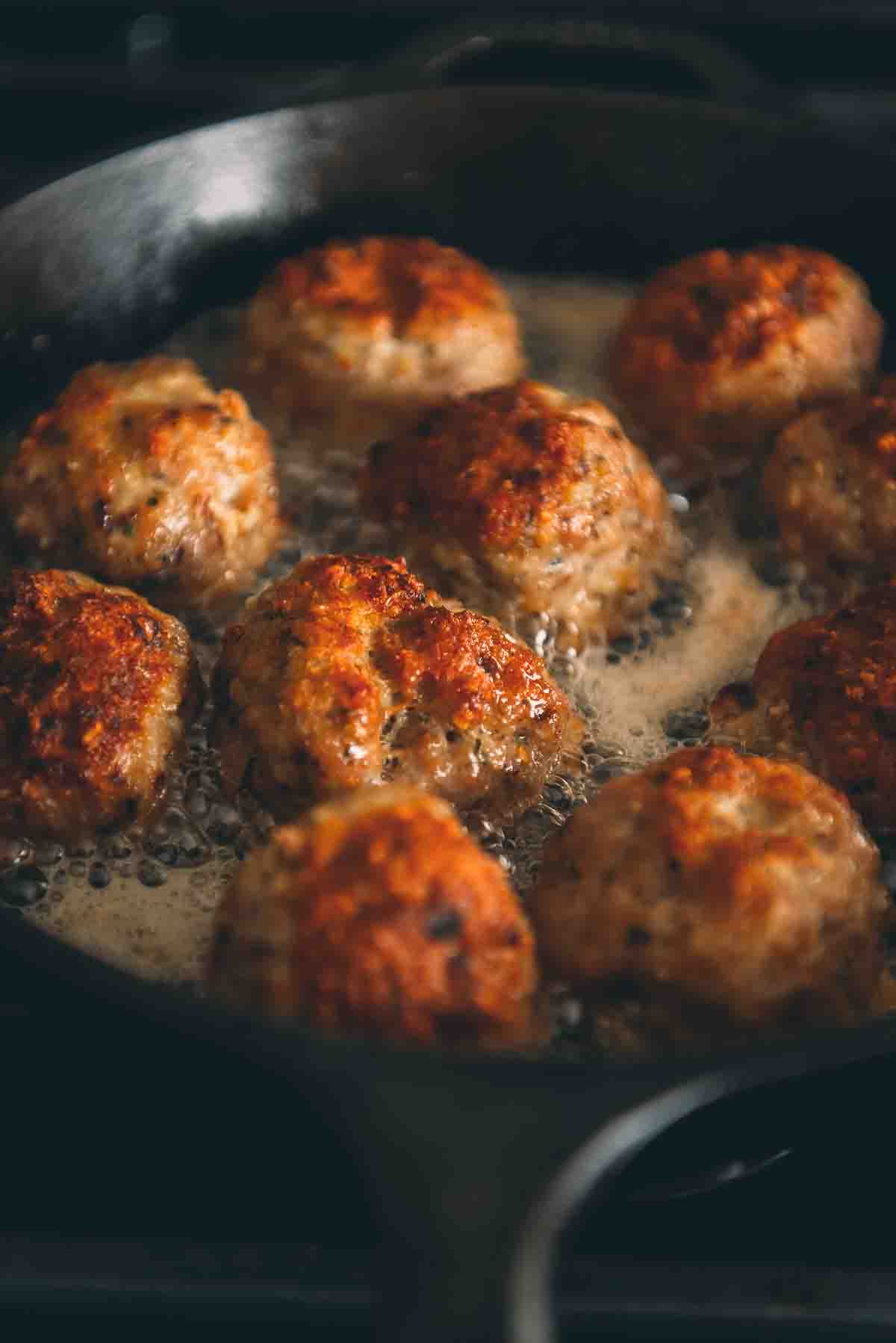 Close up of golden brown crust on top of fried meatball. 