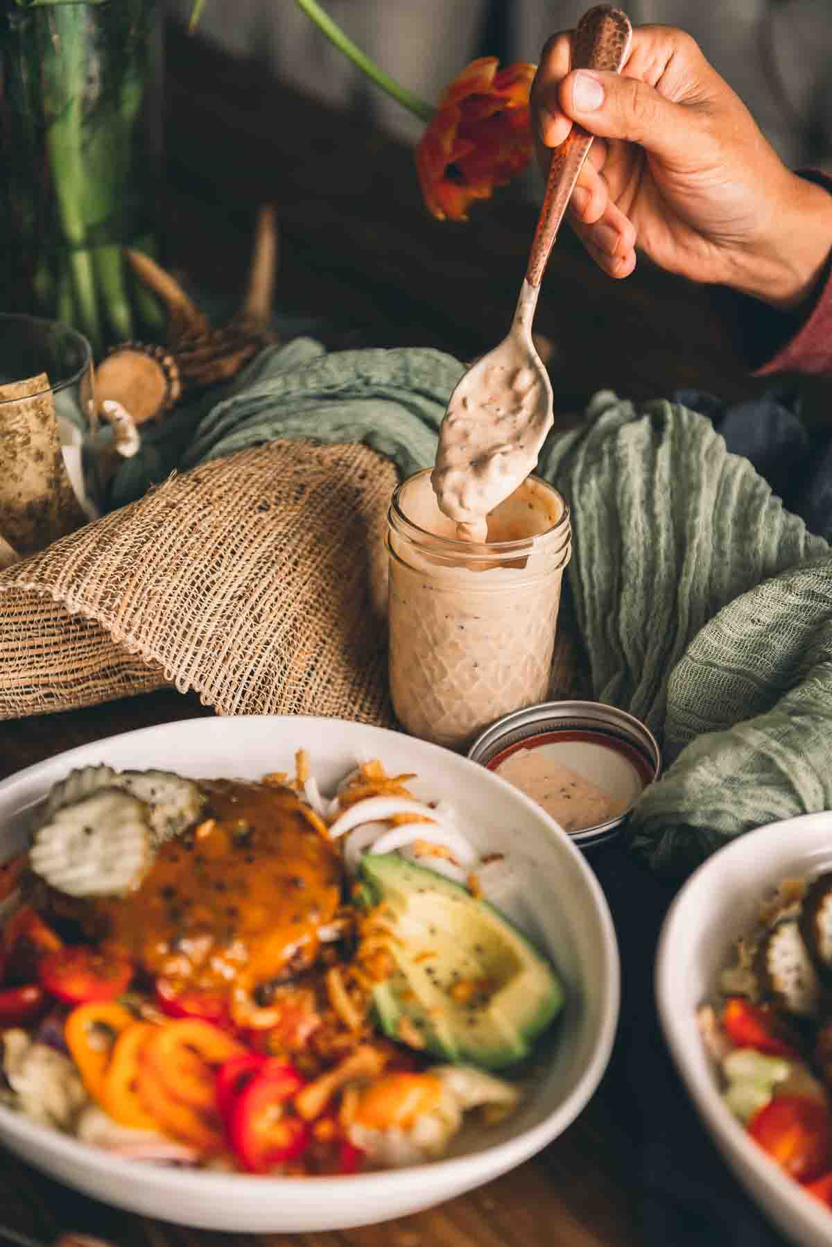 Spoonful of keto thousand island dressing to show the texture of the minced onion and relish.