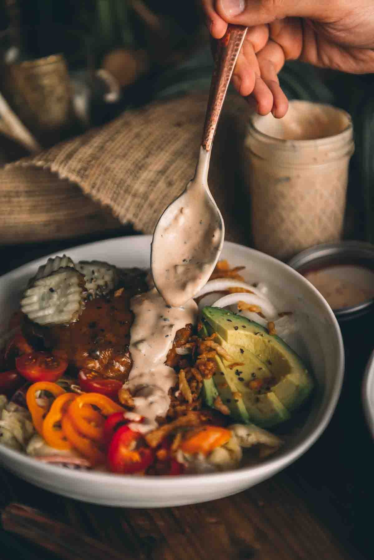 Spooning the dressing over a salad.