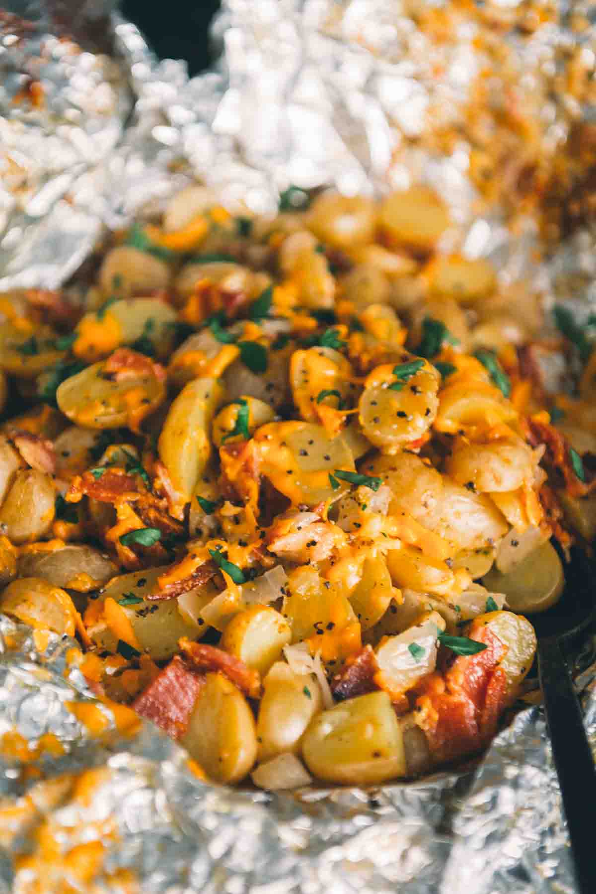 Close up of cheesy potatoes with crispy bacon, melted cheese and freshly minced parsley. 