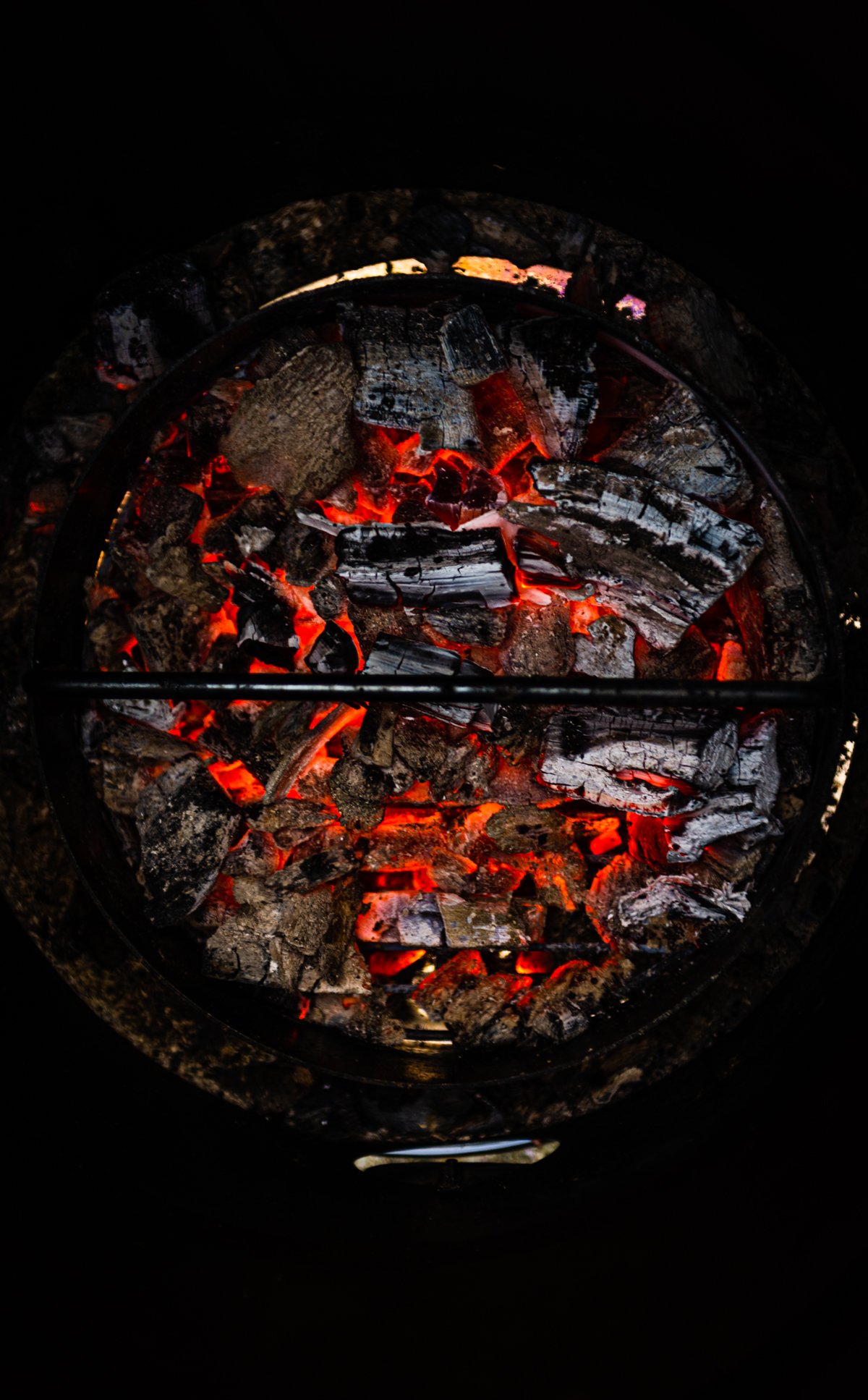Lump charcoal embers glowing in a grill.