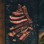 Pinterest image for grilled bone-in ribeye steaks.