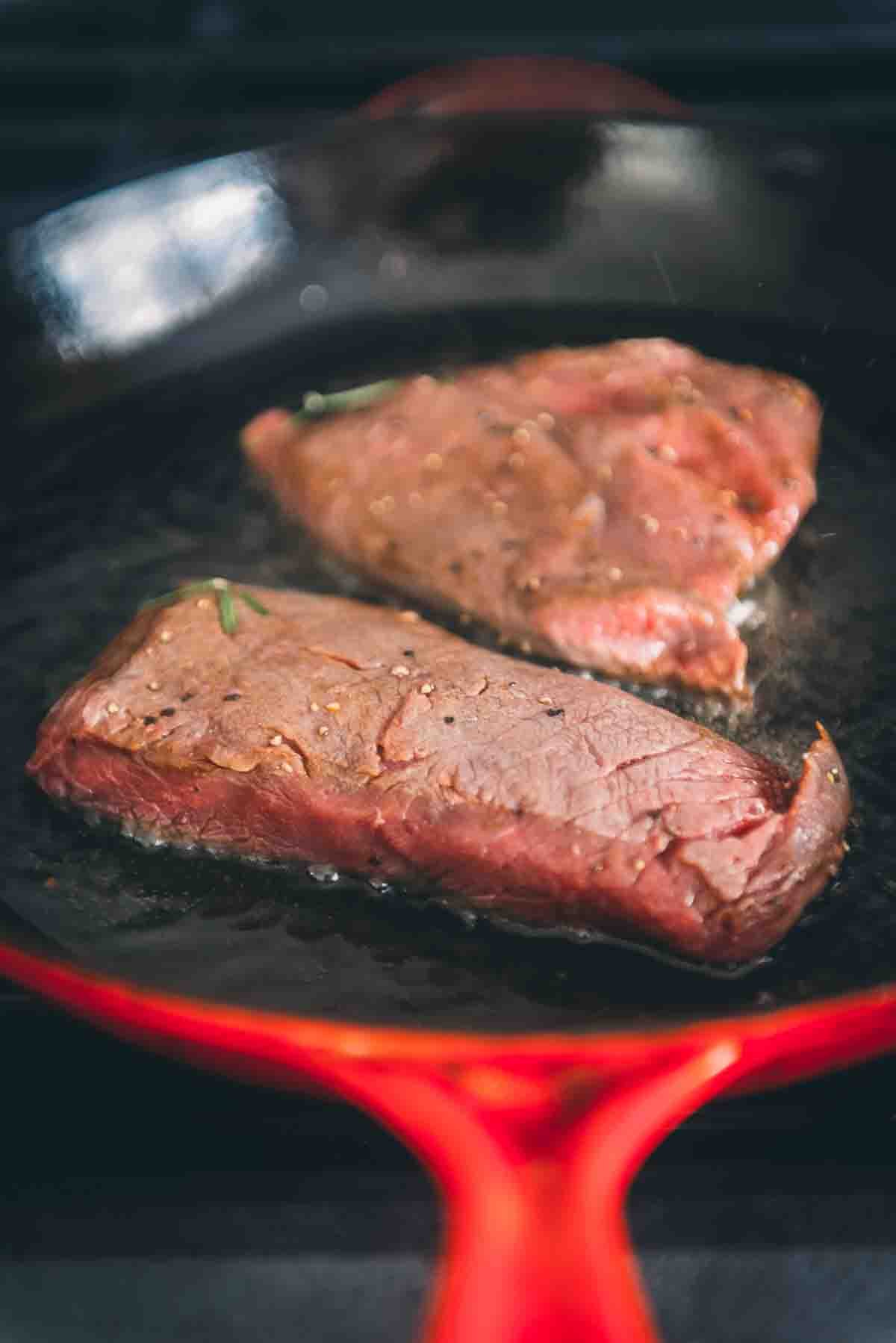 Steaks hitting a preheated skillet.