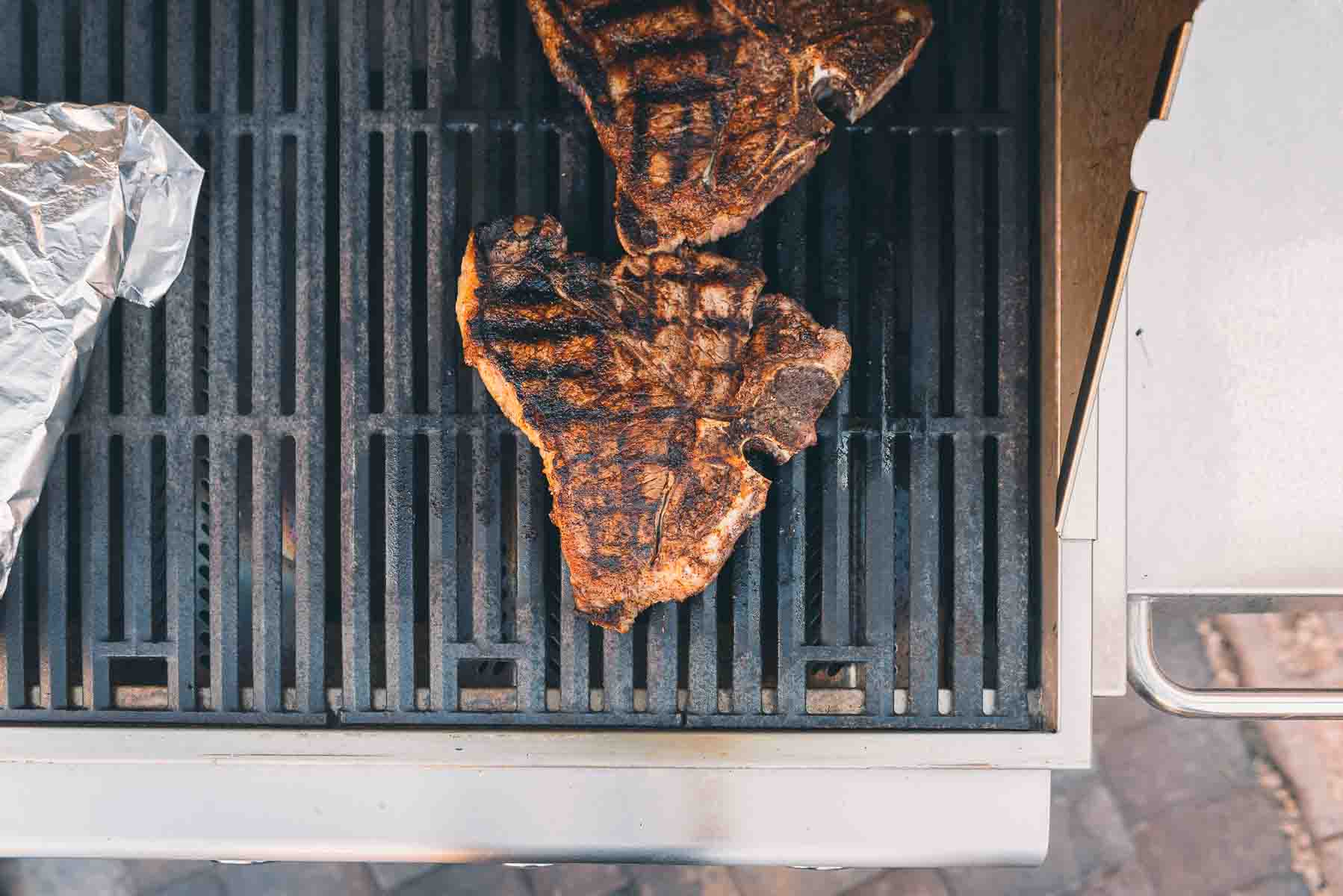 Overhead shot of steaks on a gas grill.