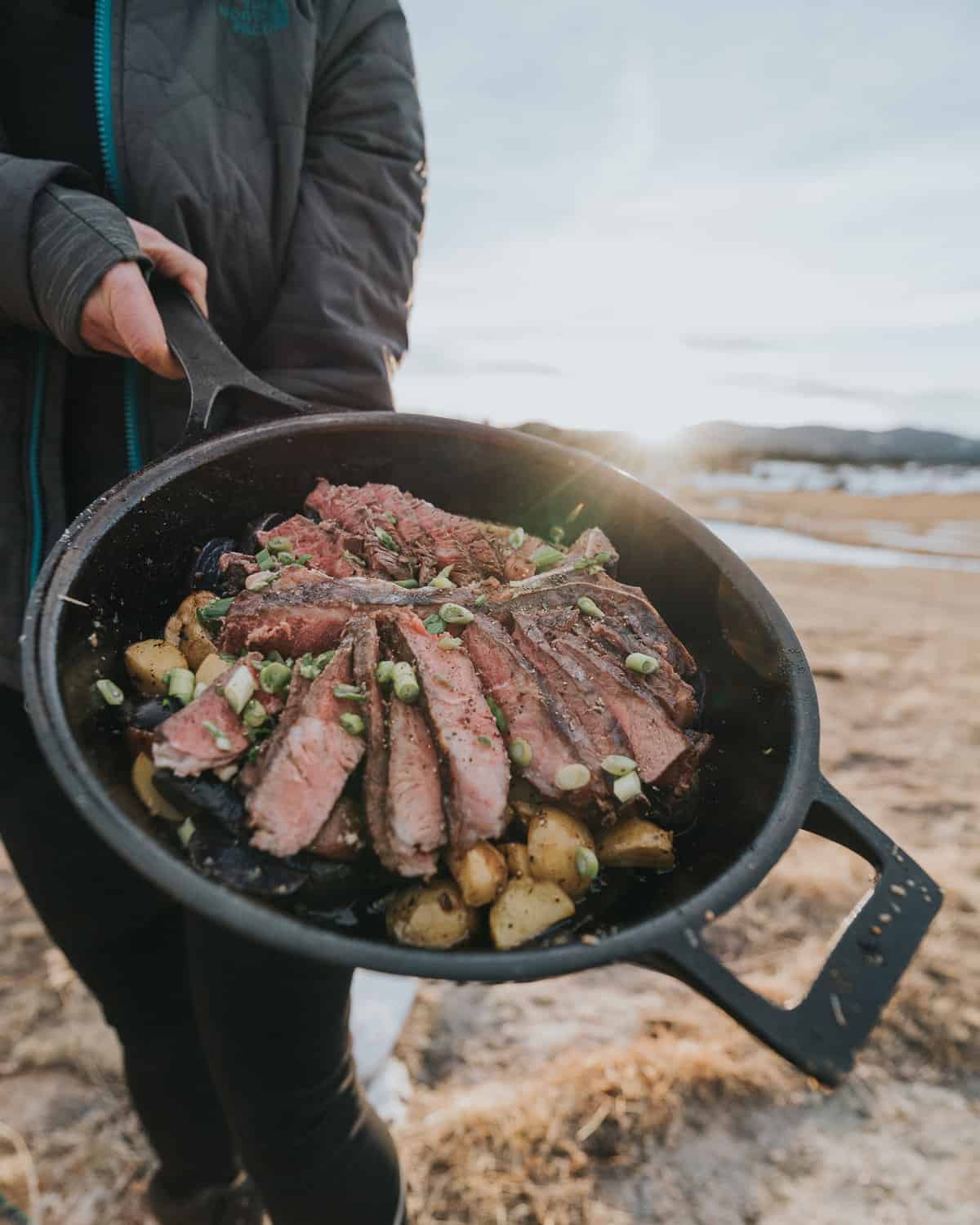 Showing a sliced steak in a skillet on a camping trip. 