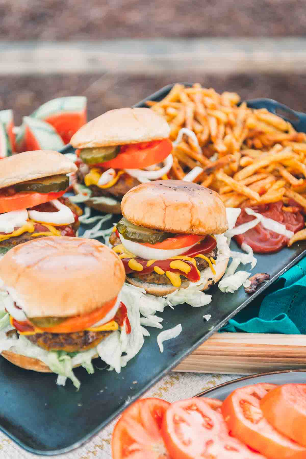 Burgers on a platter with fries. 