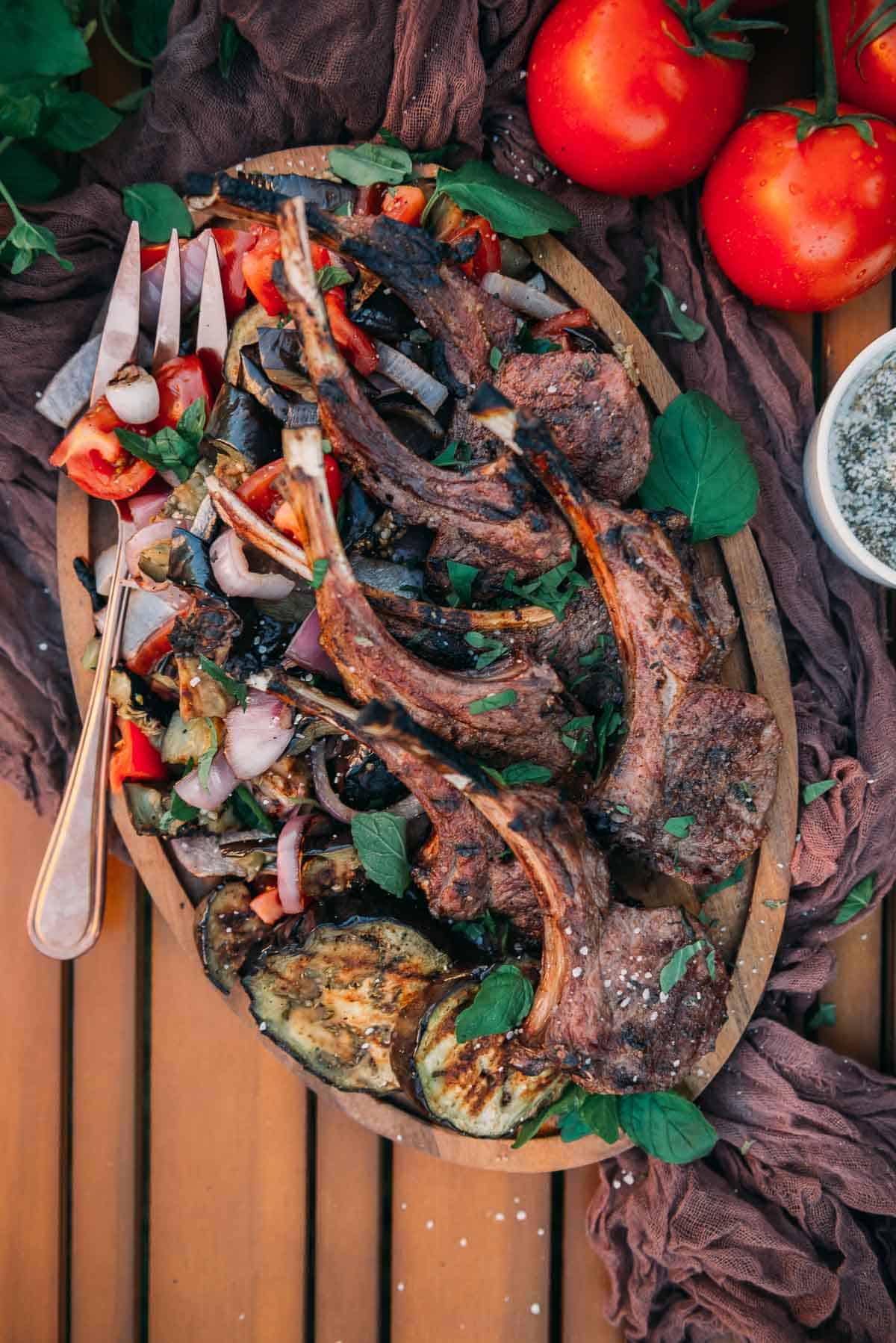 Overhead shot of seasonal platter of grilled lamb chops with grilled veggies. 