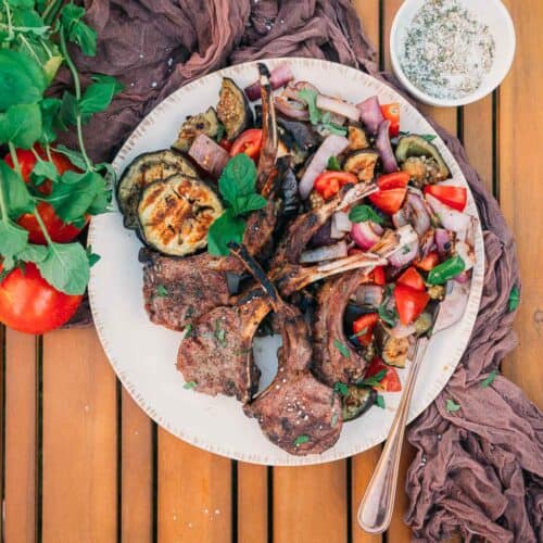 Platter of colorful fresh veggies and grilled lamb chops.