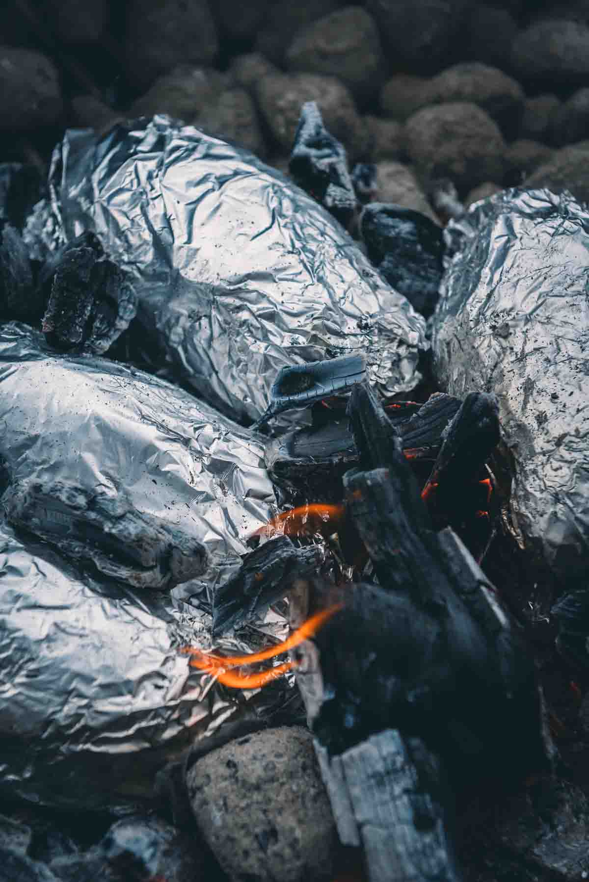 Potatoes in glowing charcoal embers. 