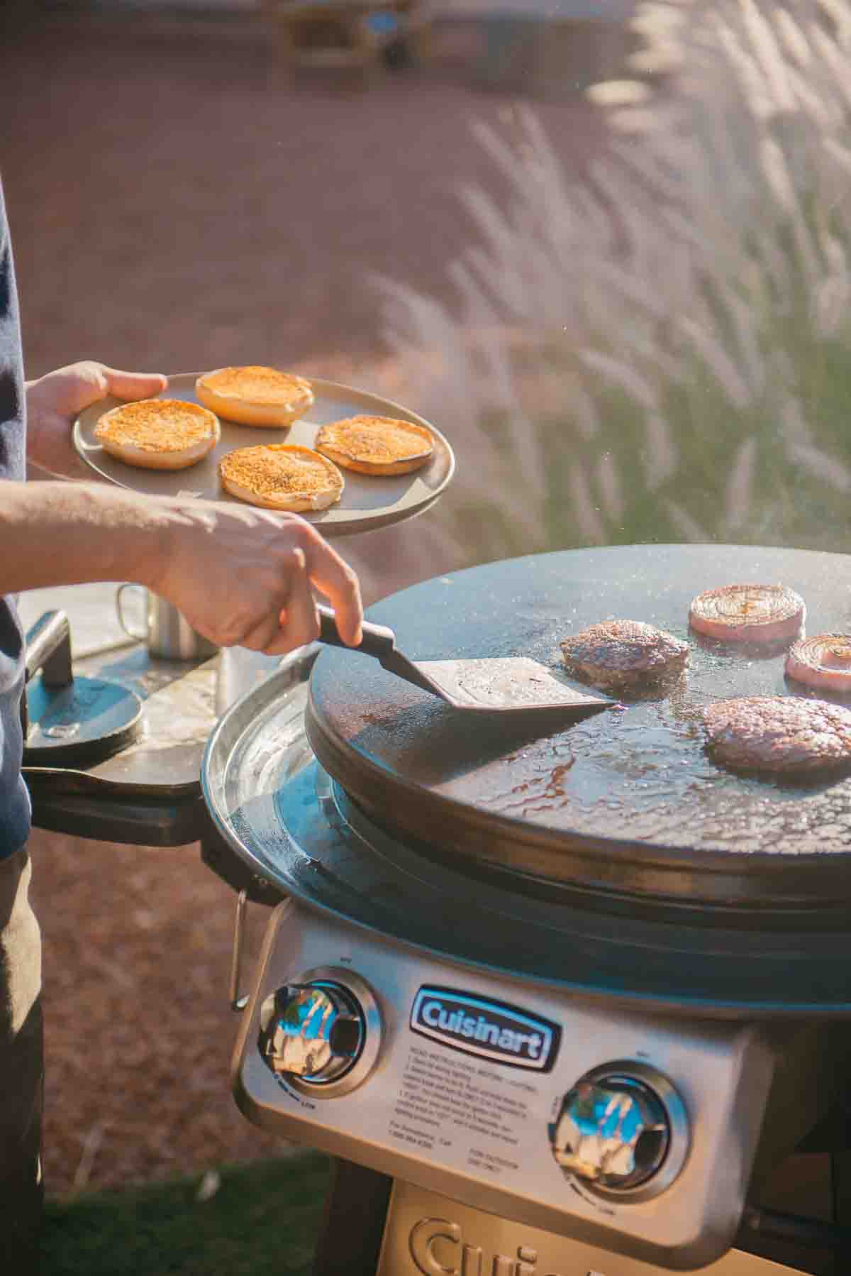 A man is grilling food on a burger.
