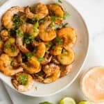 Overhead of white bowl filled with cooked shrimps from the air fryer.