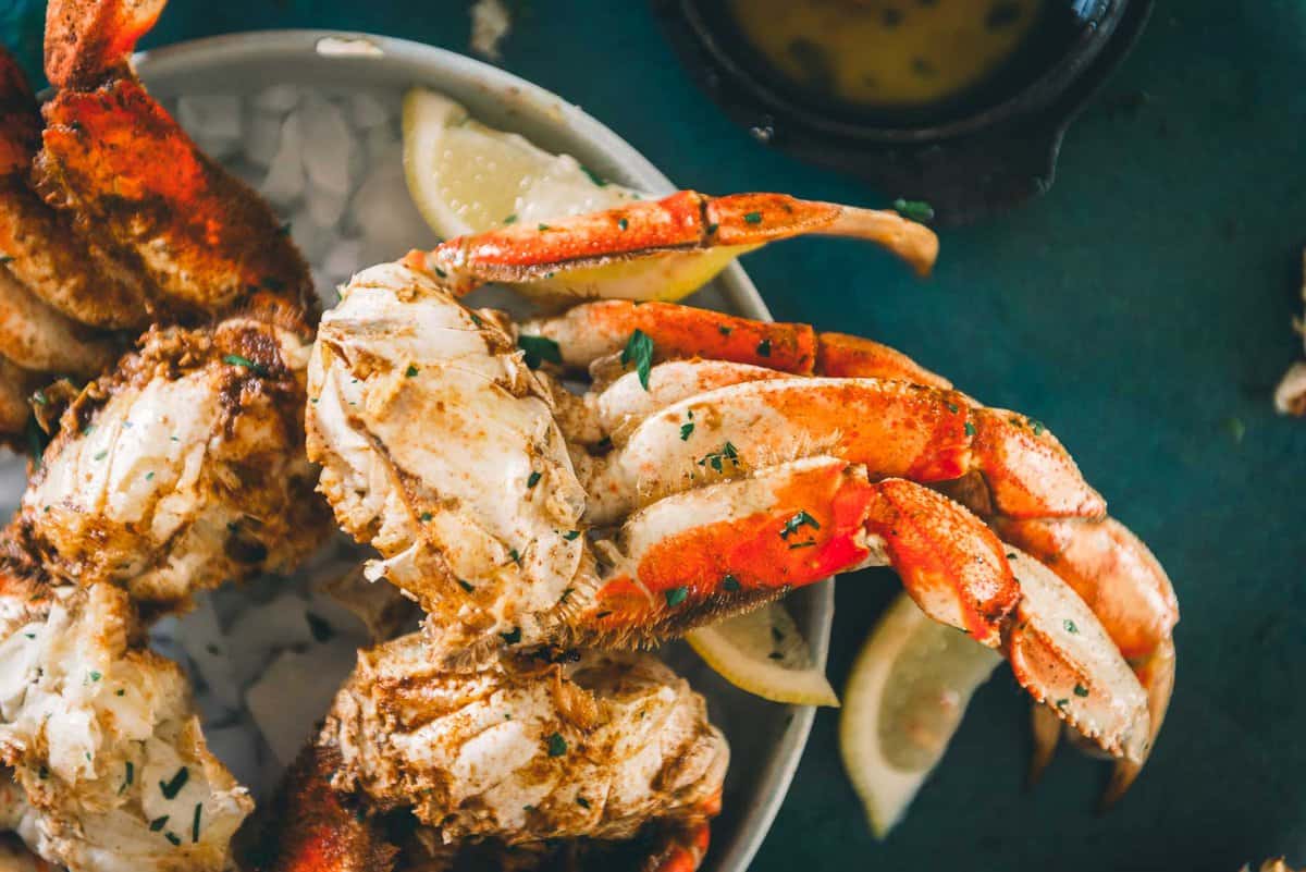 Bright red crab legs seasoned with spices and served on a platter of ice to enjoy. 