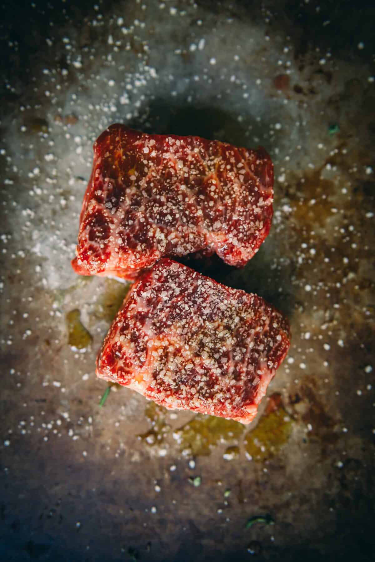 Steaks salted and rubbed with oil.