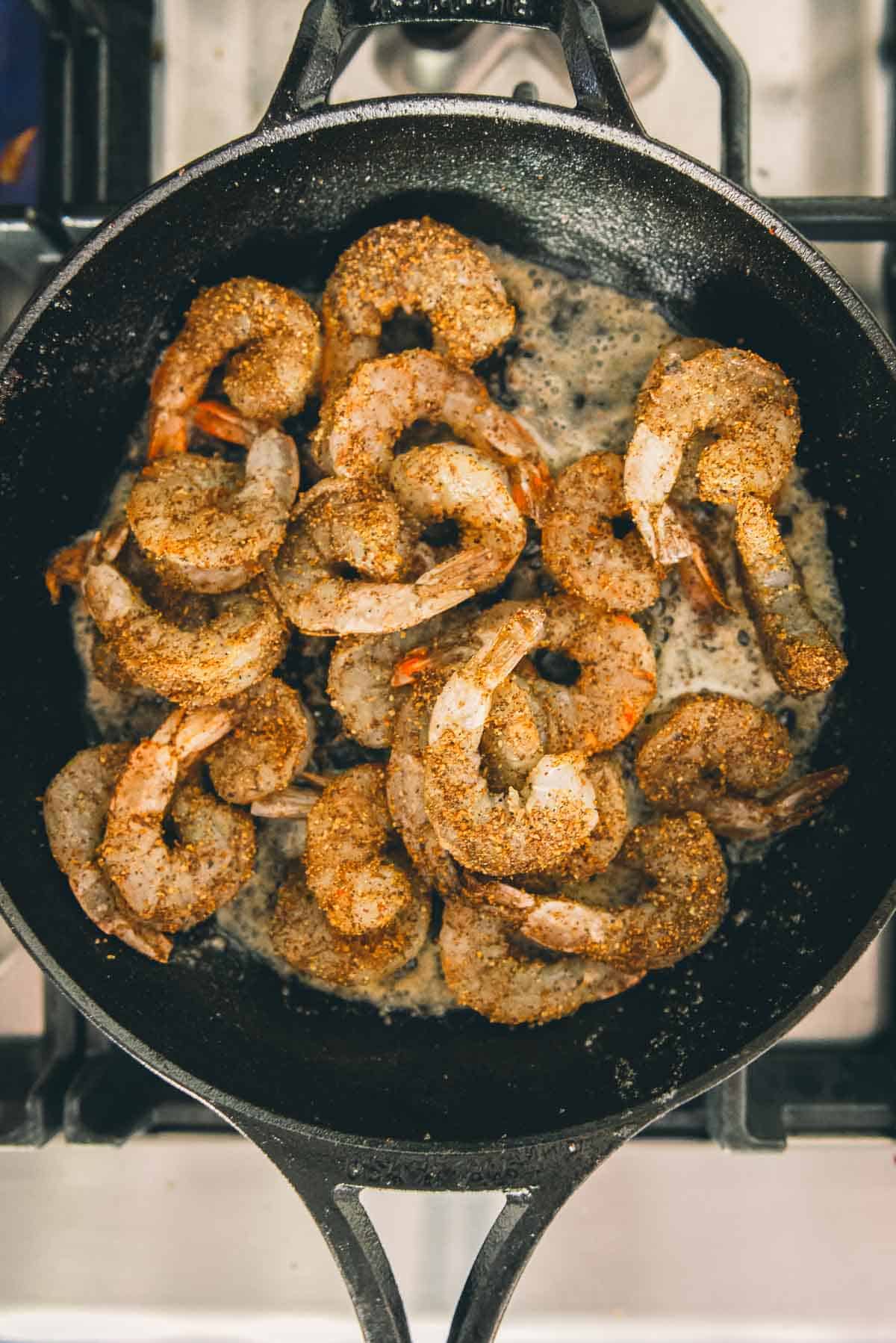 Shrimp added to the pan with spices to cook.