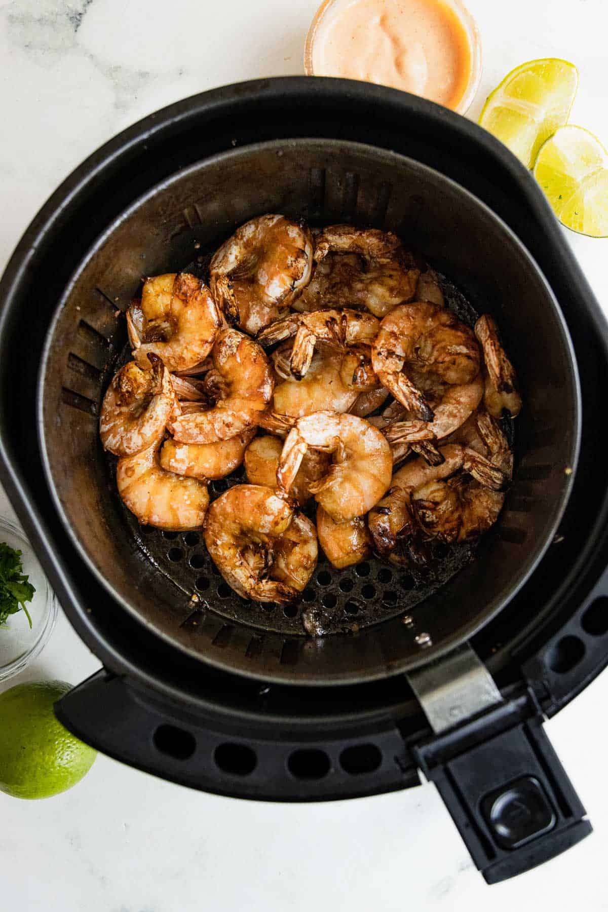 Cooked shrimp in the air fryer basket. 