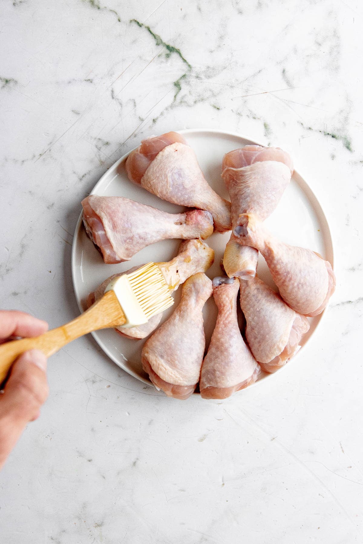 Brushing the chicken with oil.