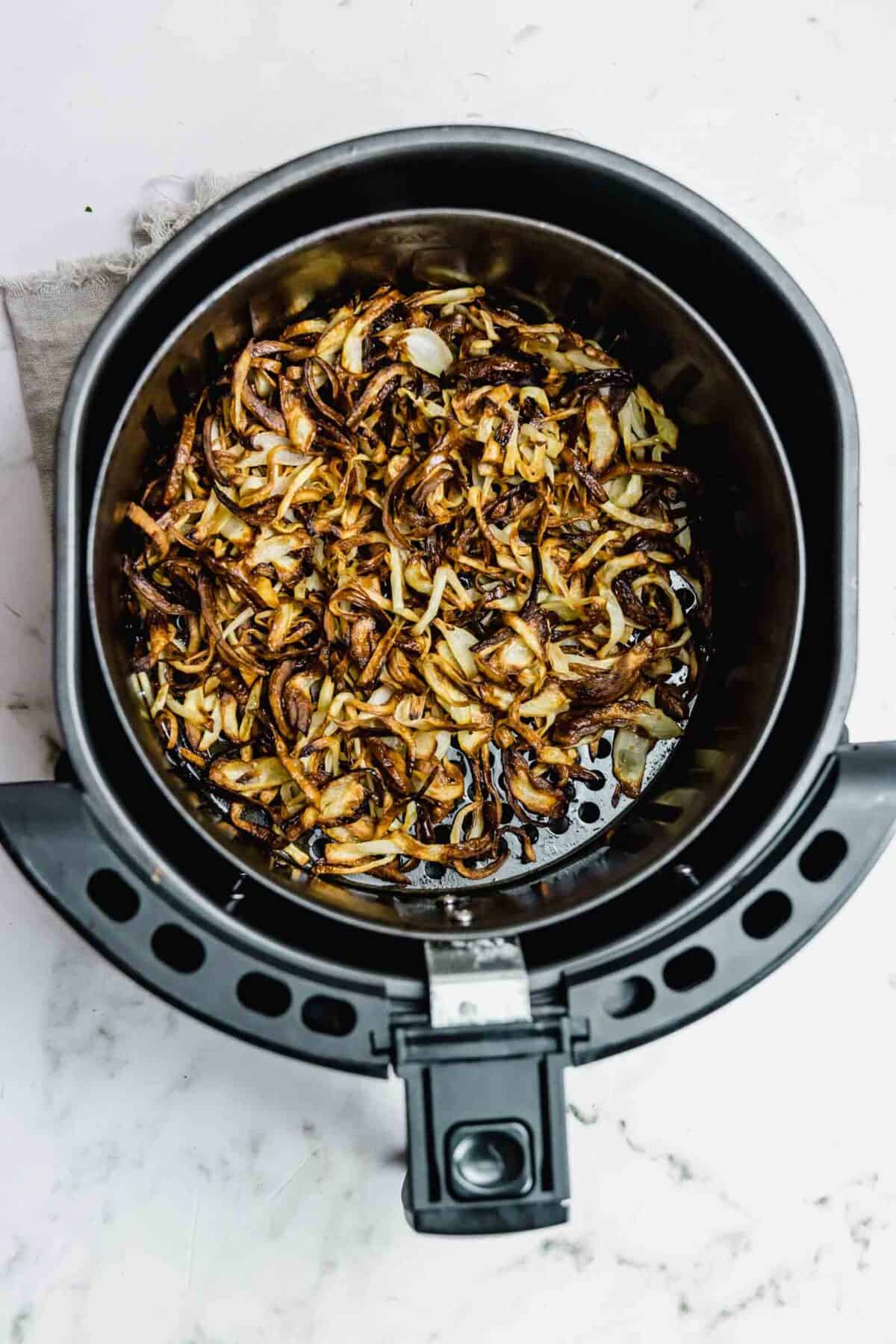 Cooked air fried onions in the basket.