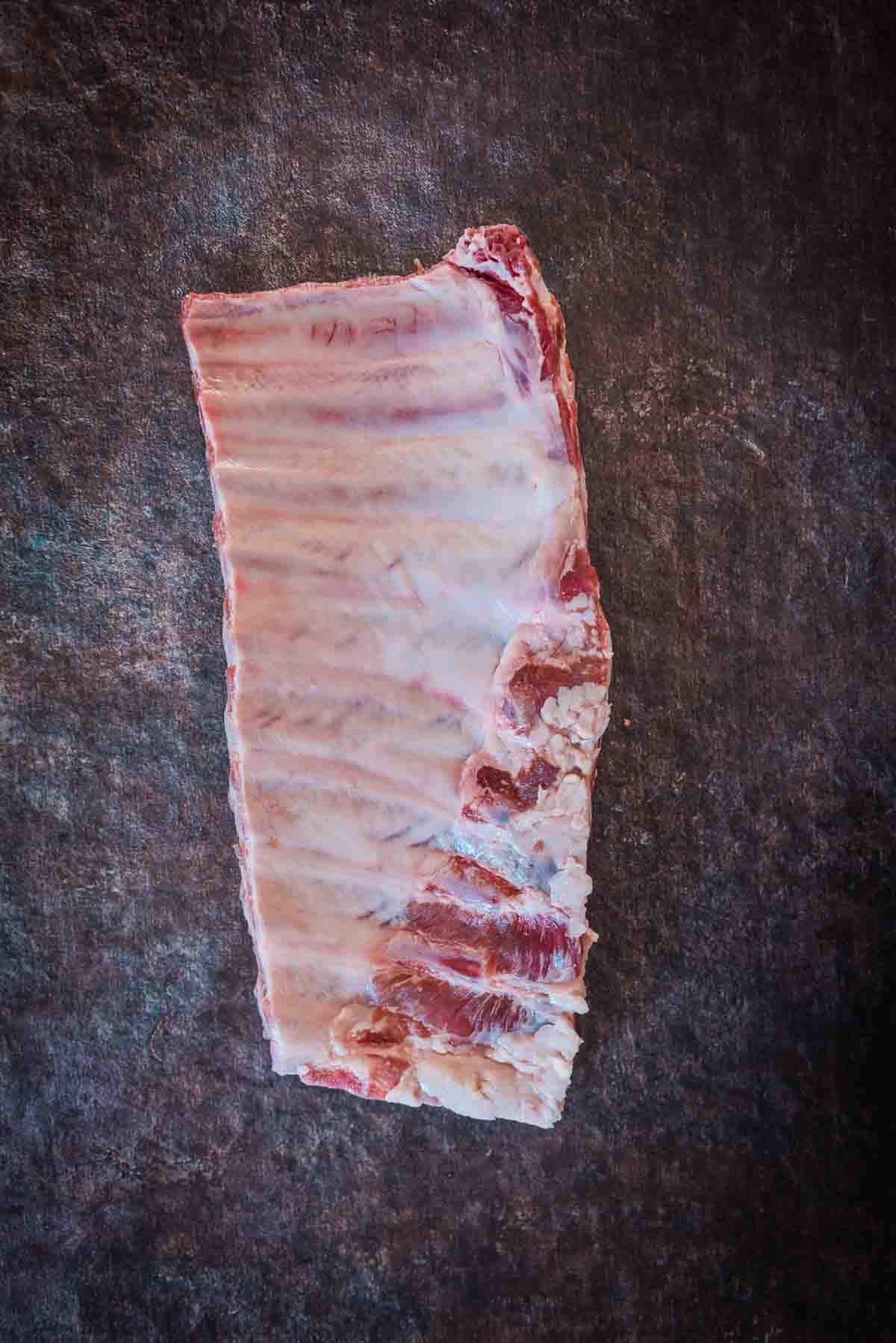 Bone side of a uniform rack of ribs showing the thing membrane.