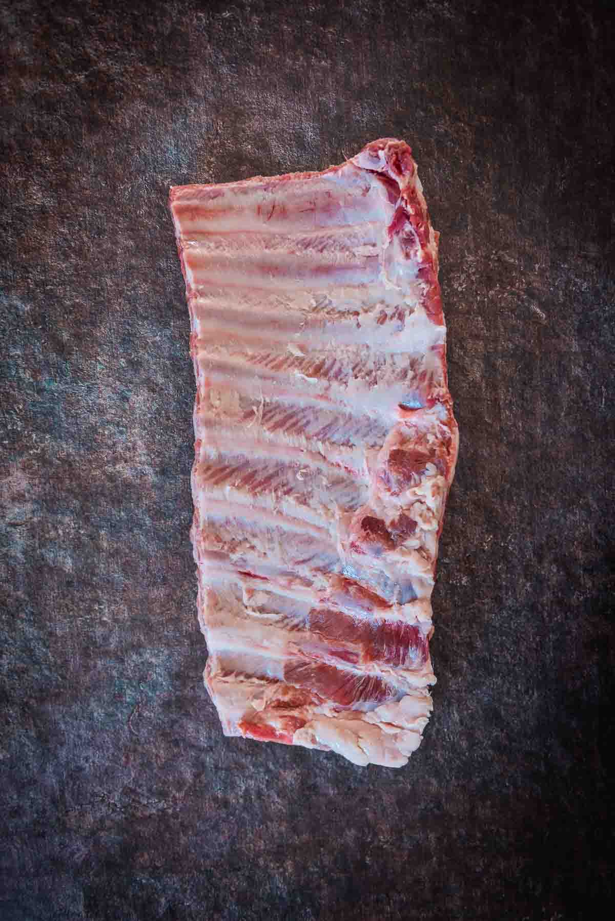 Bone side of a full spare rib rack showing membrane removed.