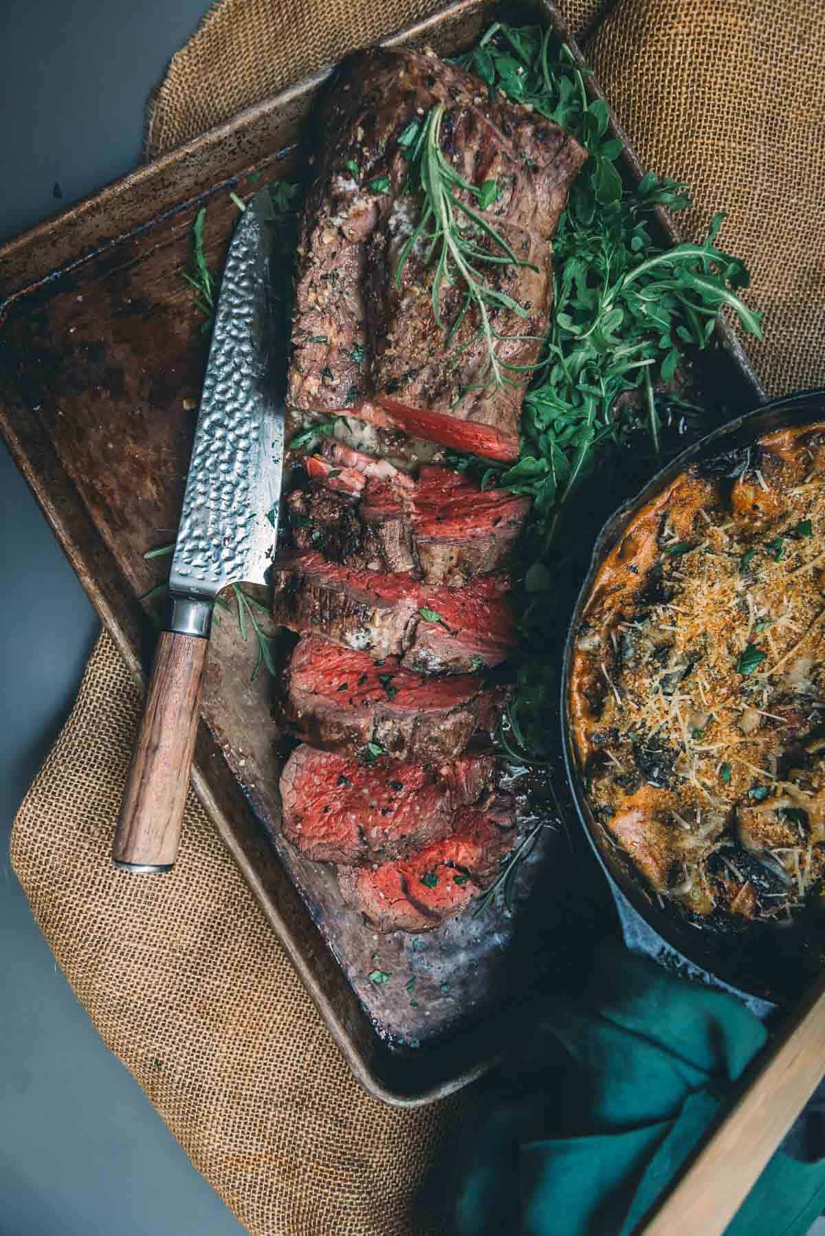 Sliced beef tenderloin on a sheet pan for serving. 