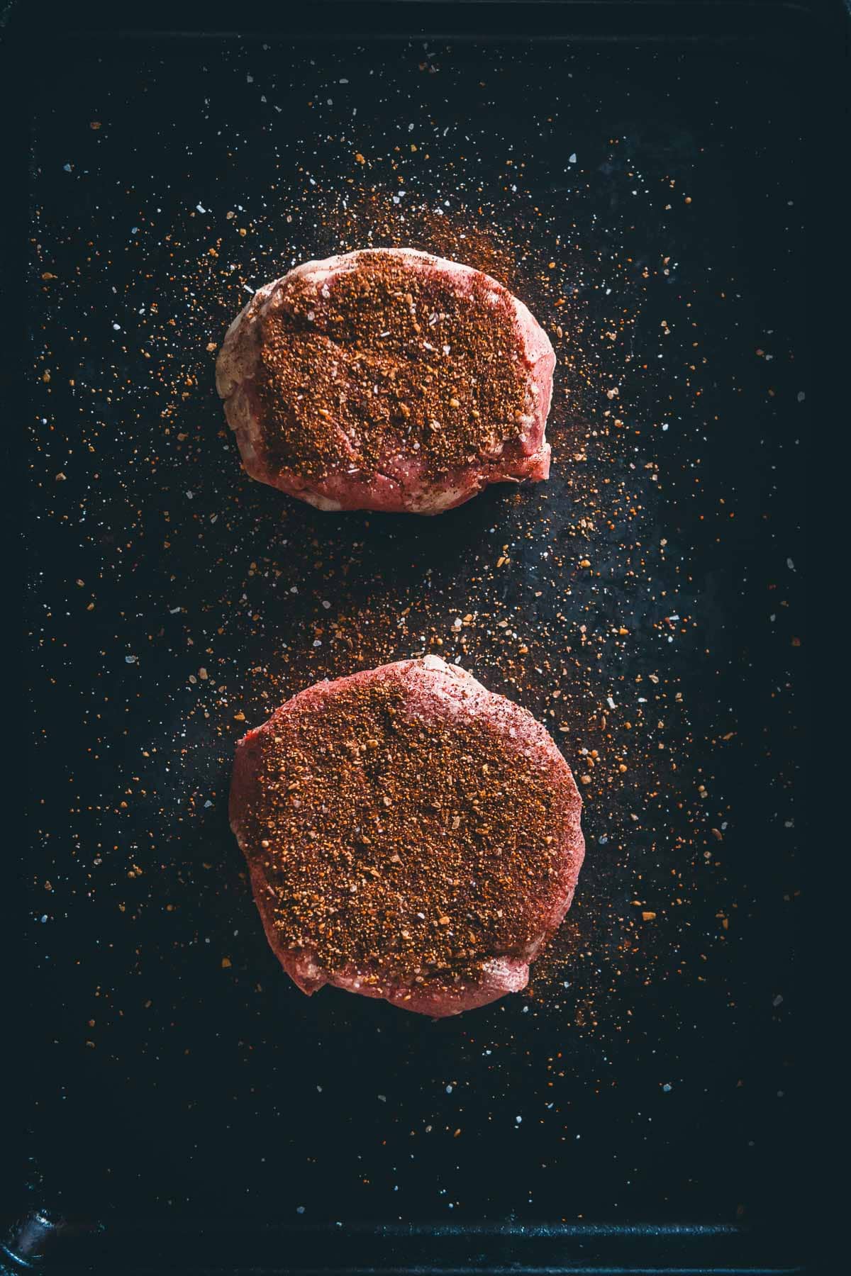 Chuck steaks coated in spices.
