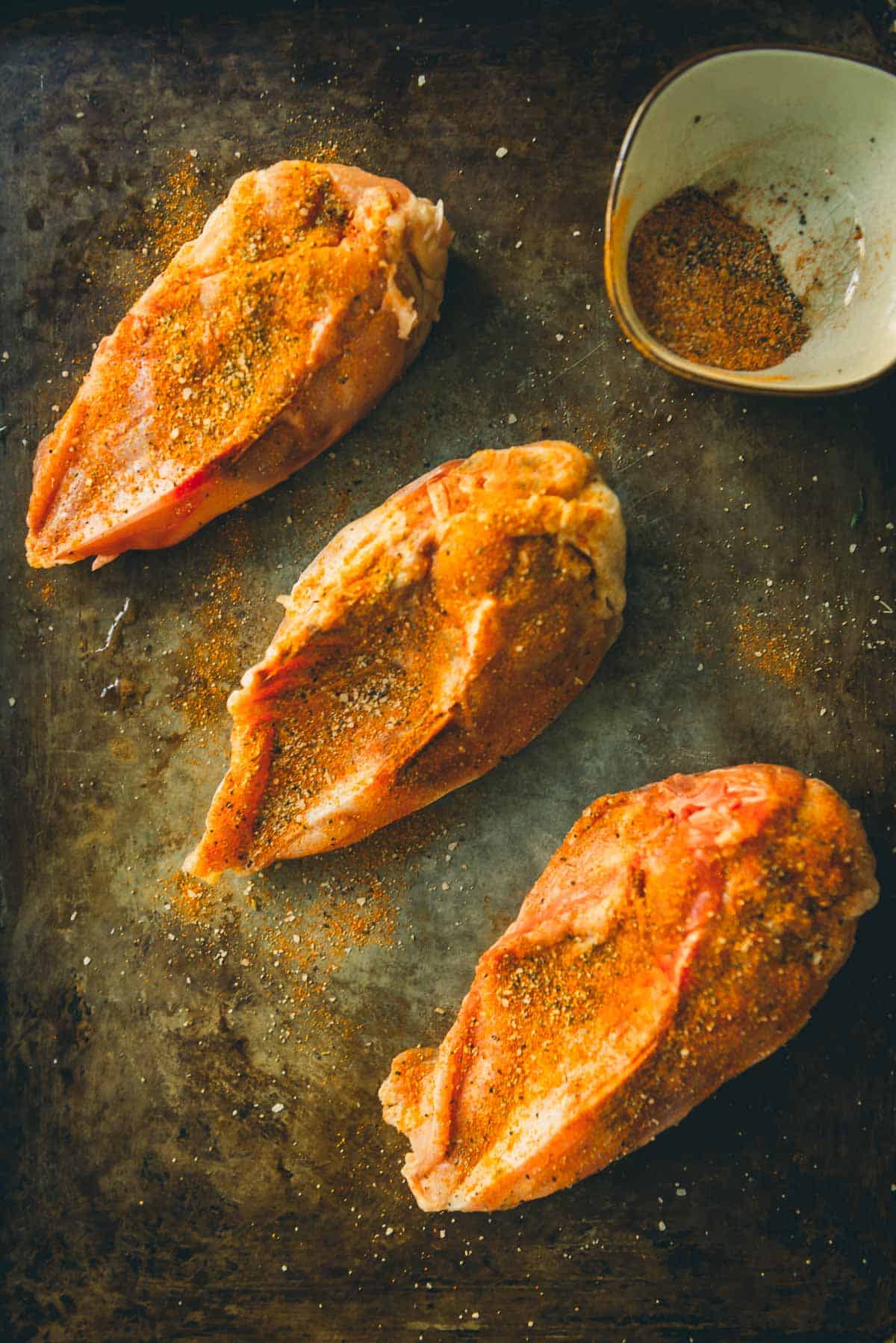 Split chicken breasts rubbed with spices.