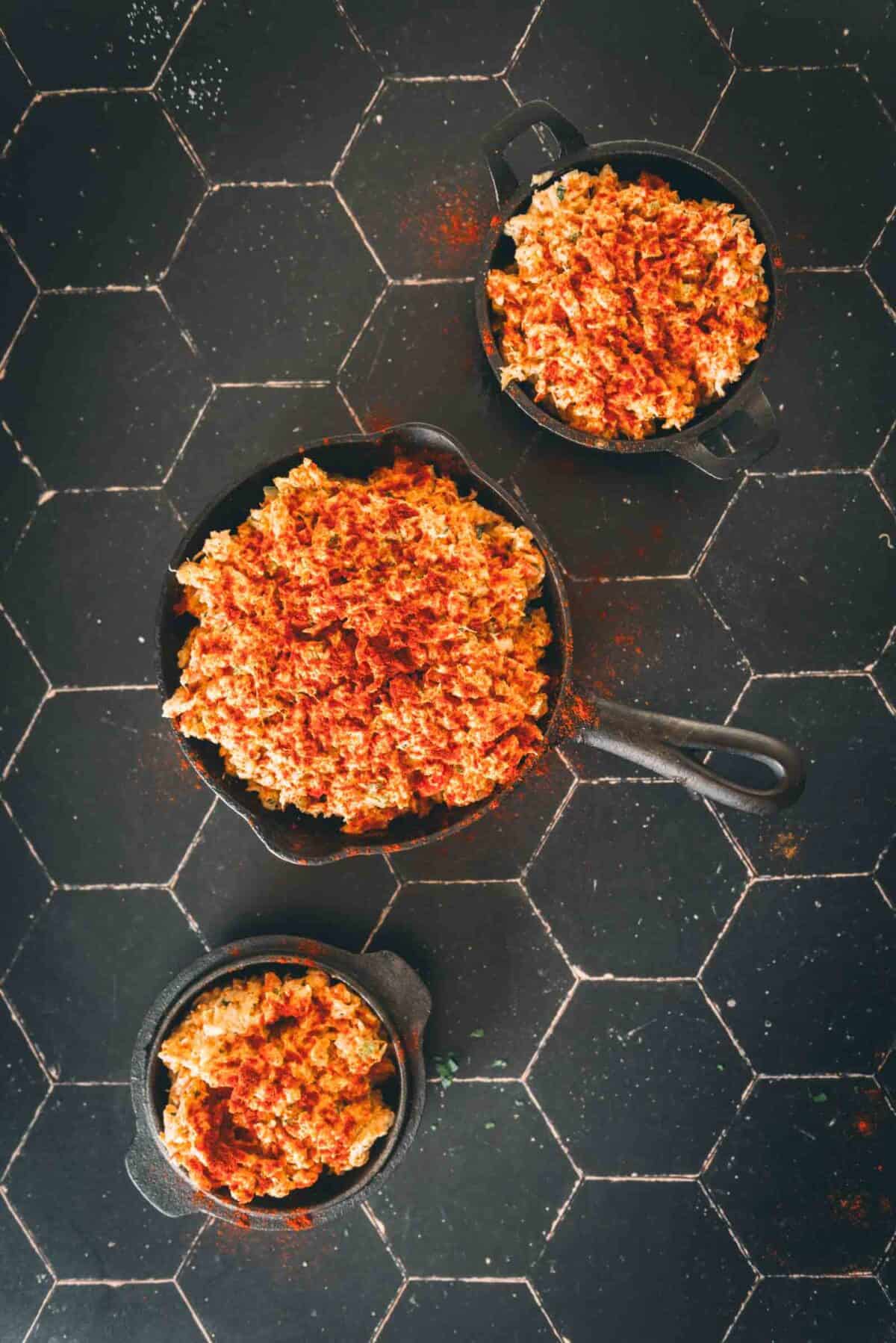 Skillets filled with the crab stuffing.
