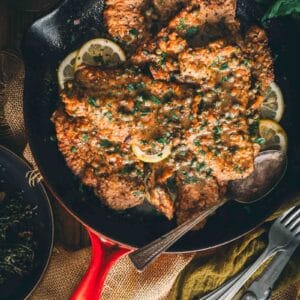A skillet filled with veal with lemon and herbs.