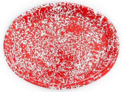 A red and white splattered plate on a white surface.
