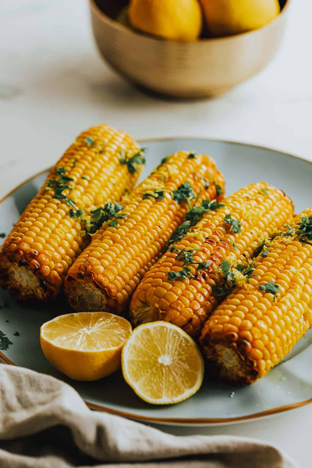 Air fried corn on the cob with lemon slices.
