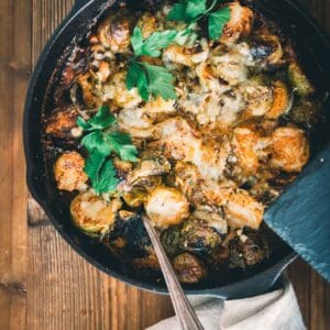 A skillet filled with brussels sprouts and cheese.