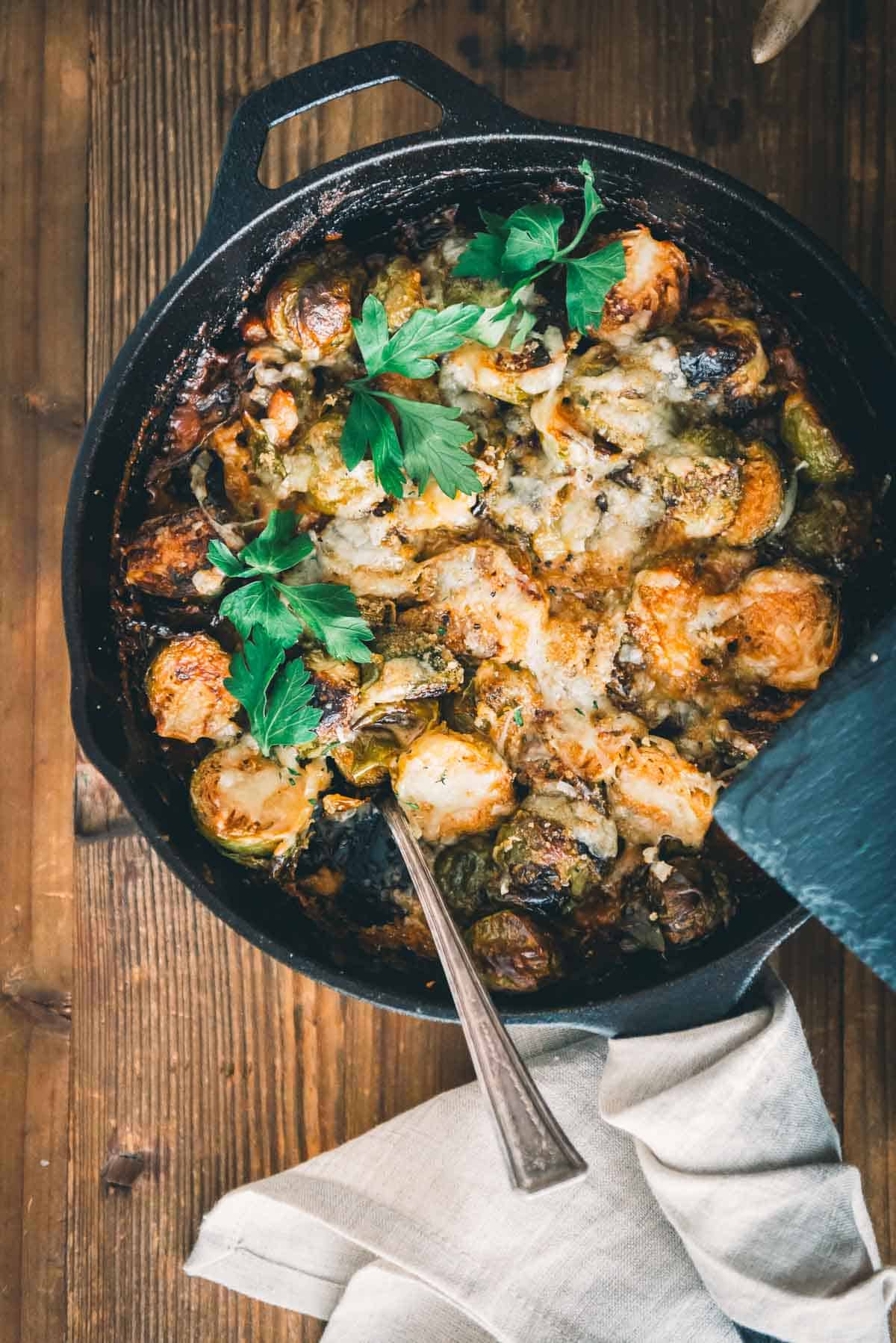 A skillet filled with brussels sprouts and cheese.