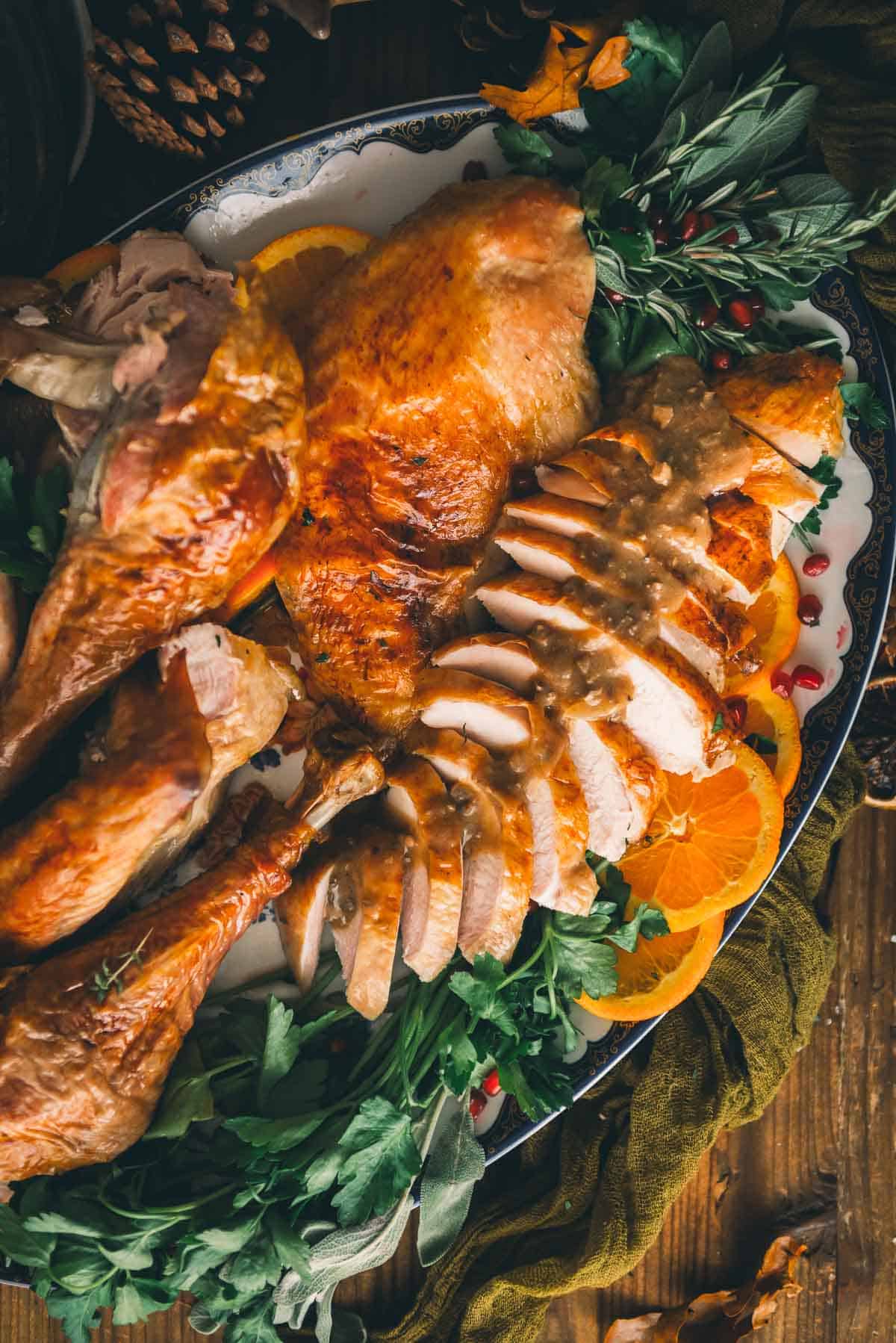 Golden brown turkey breast sliced with gravy on top.
