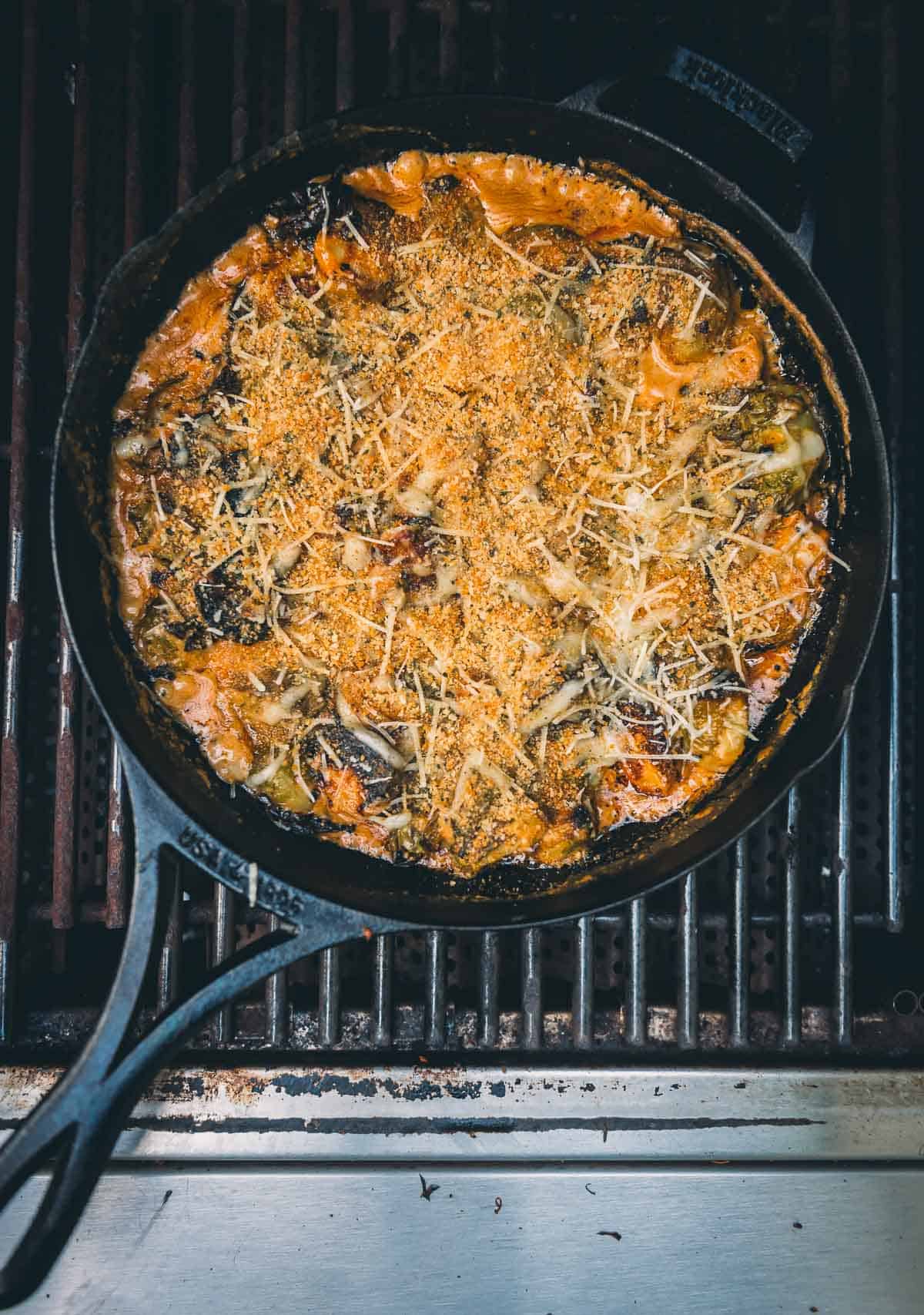 A skillet full of food on a grill.