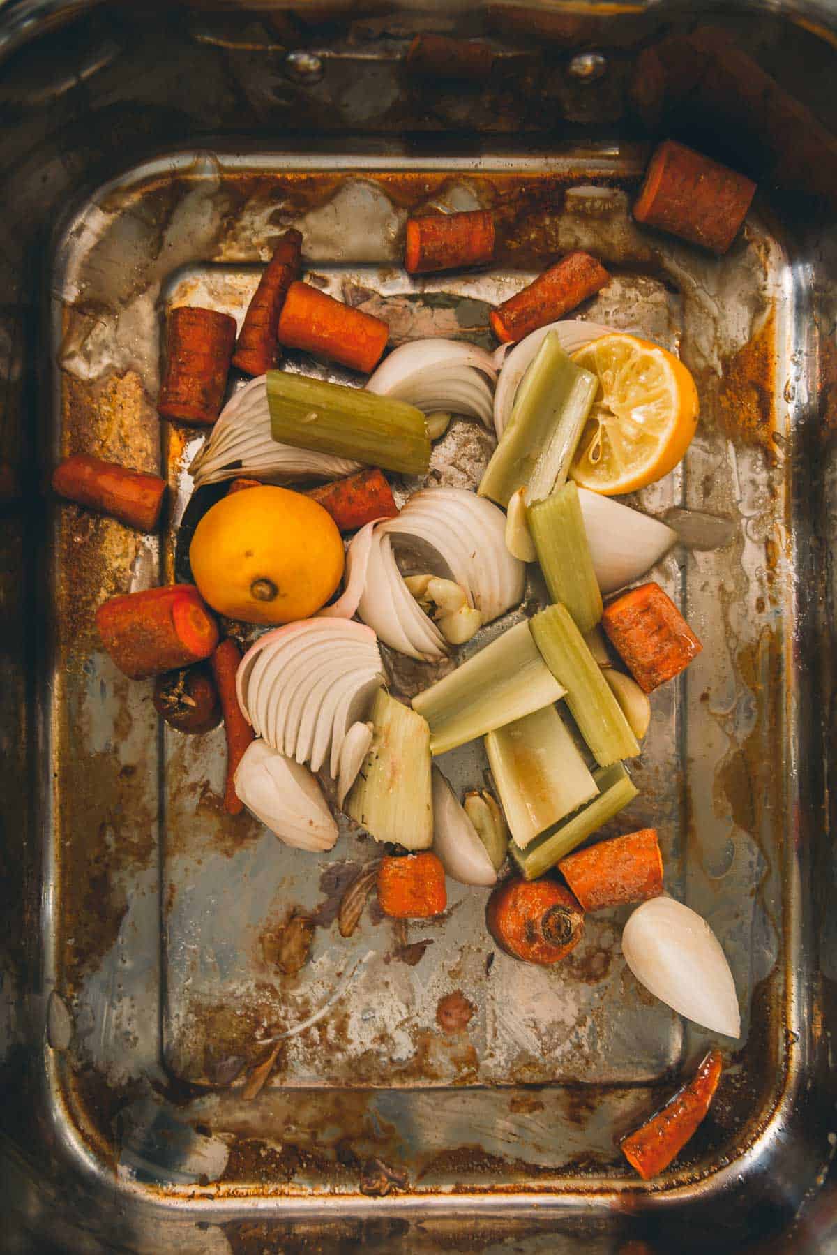 Bottom of pan showing roasted veggies from under the turkey and brown bits stuck to the bottom.