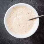 A white bowl with a spoon in it.