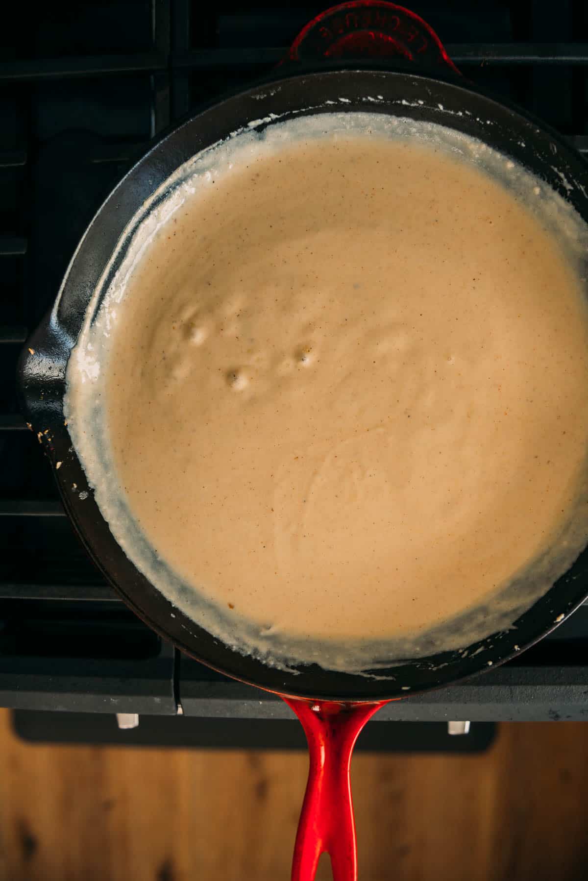 A skillet with a sauce in it.