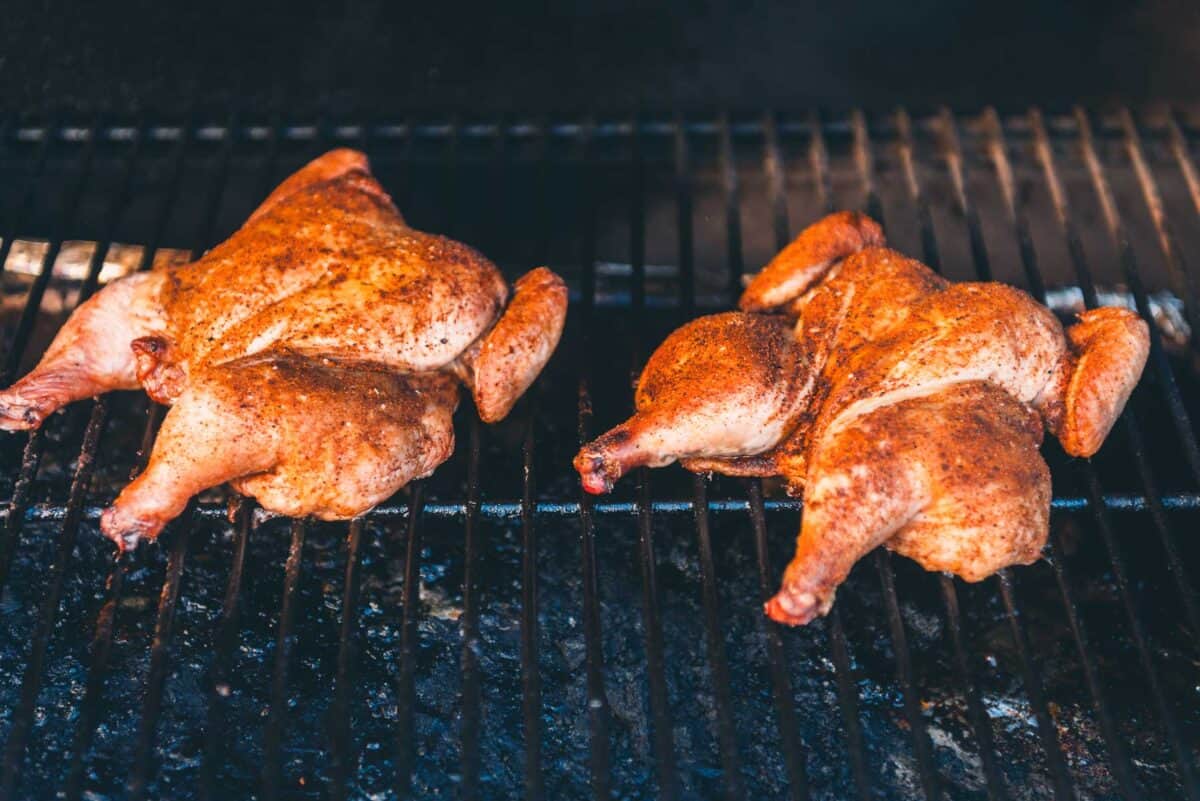 Two roasted Cornish hens on a grill.