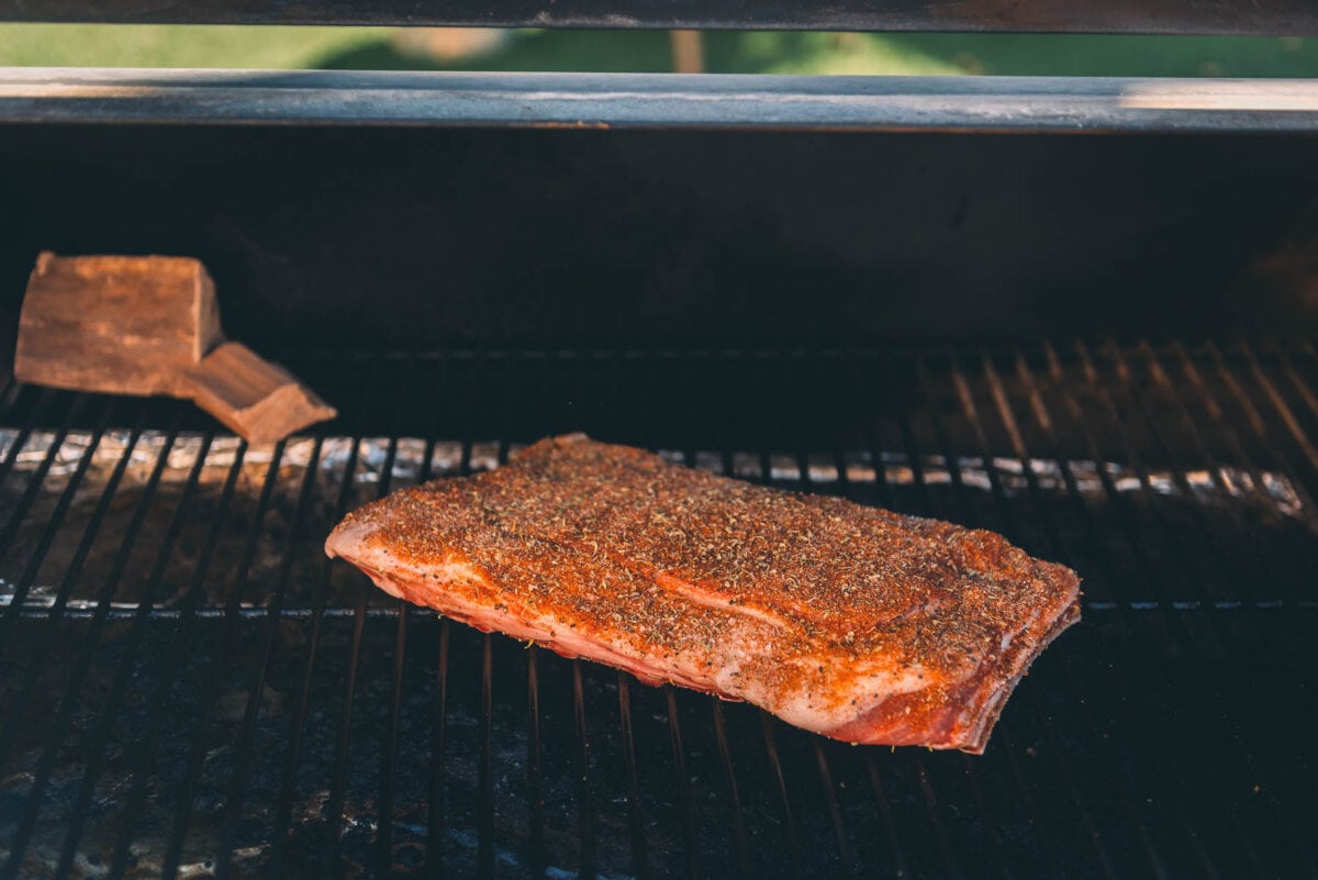 A piece of meat is being cooked on a grill.
