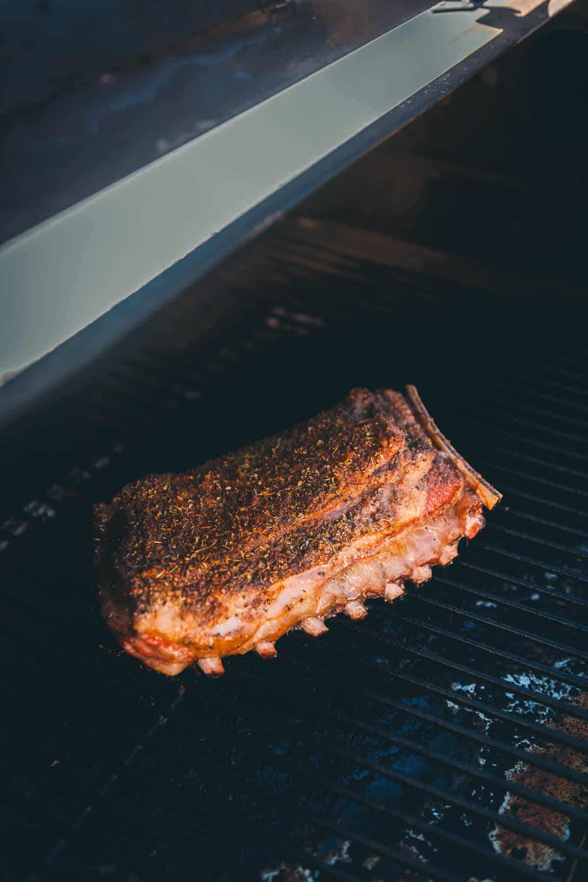 Ribs being cooked on a grill.