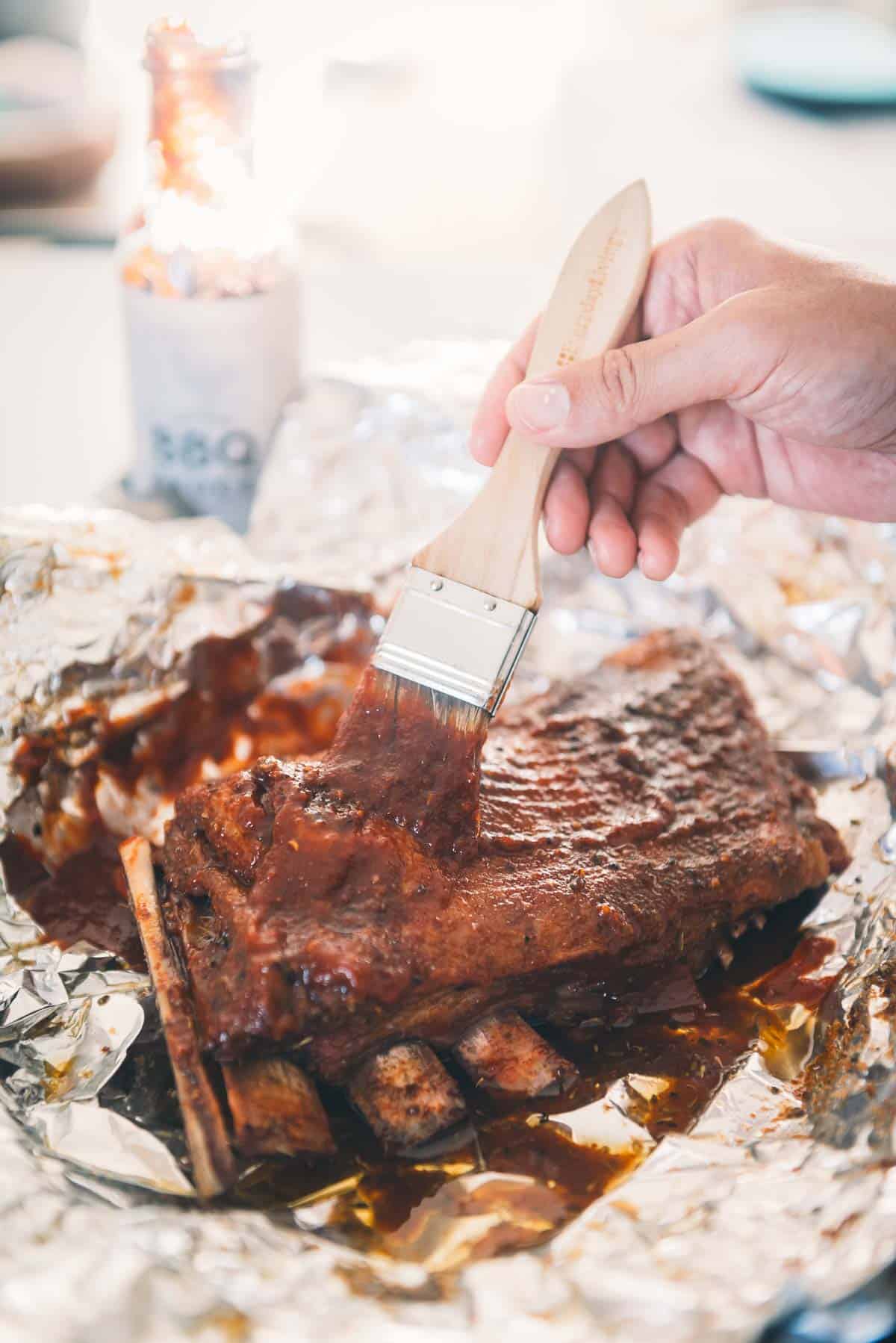 Bbq ribs on foil with a basting brush.