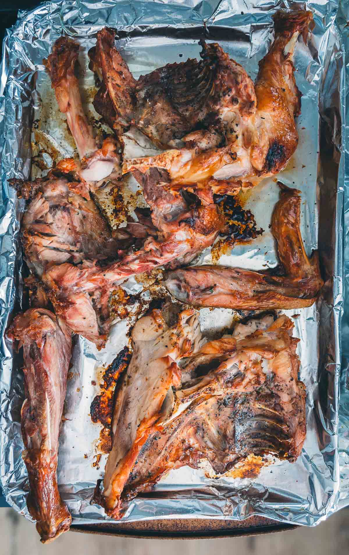 Roasted turkey bones on tin foil lined baking sheet.