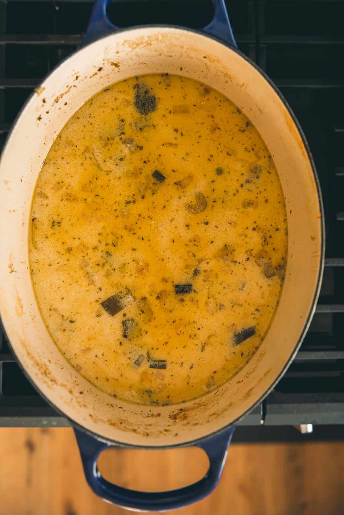 A pot of soup on a stove top.